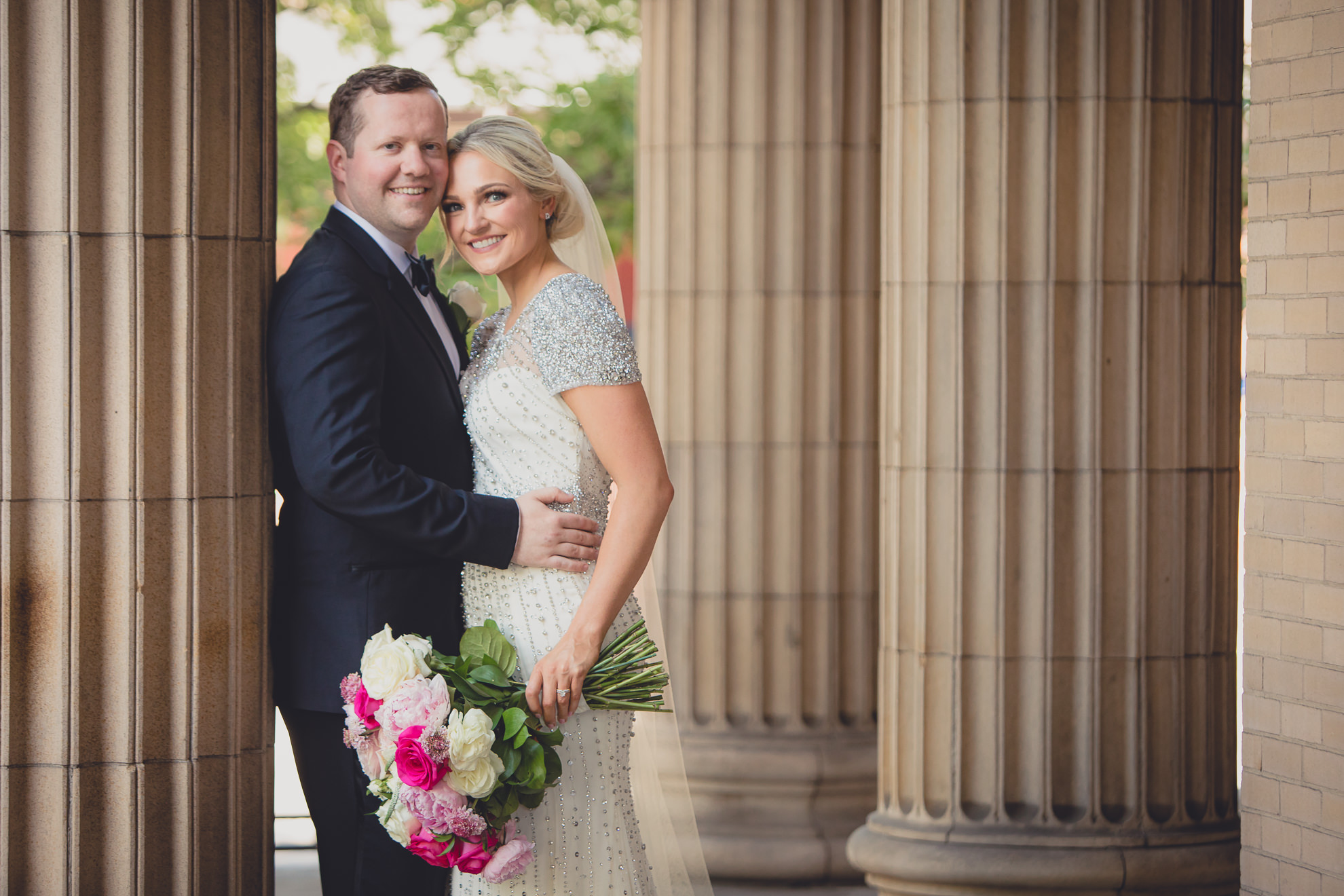 Bride and groom pose for wedding portrait on front steps of Karpeles Manuscript library in Buffalo, NY