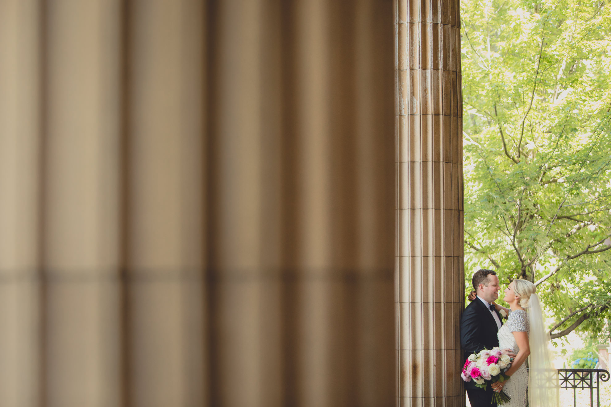Bride and groom pose for wedding portrait on front steps of Karpeles Manuscript library in Buffalo, NY
