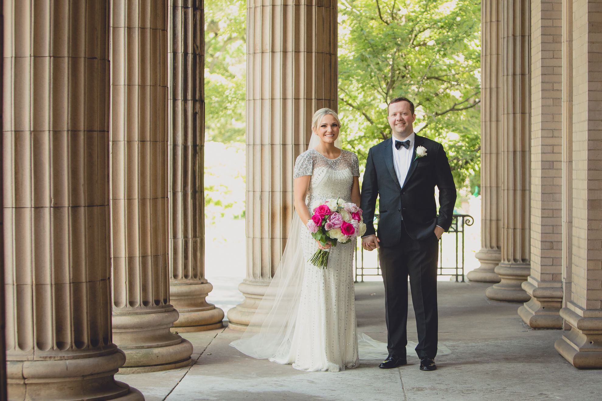 Bride and groom pose for wedding portrait on front steps of Karpeles Manuscript library in Buffalo, NY