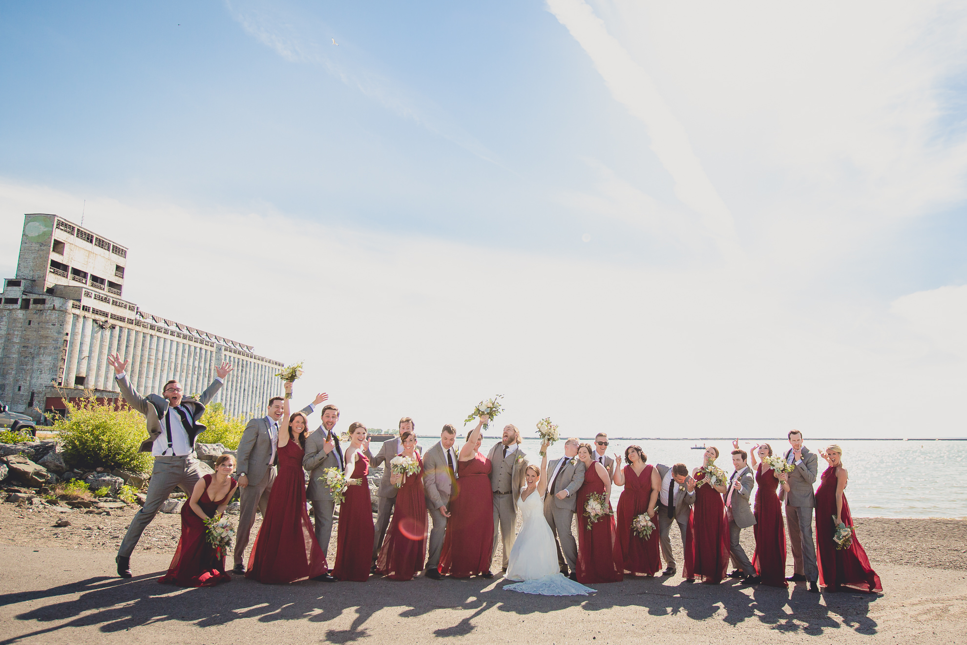 wedding party poses for photographer at wedding at Gallagher Beach on Outer Harbor of Buffalo, NY