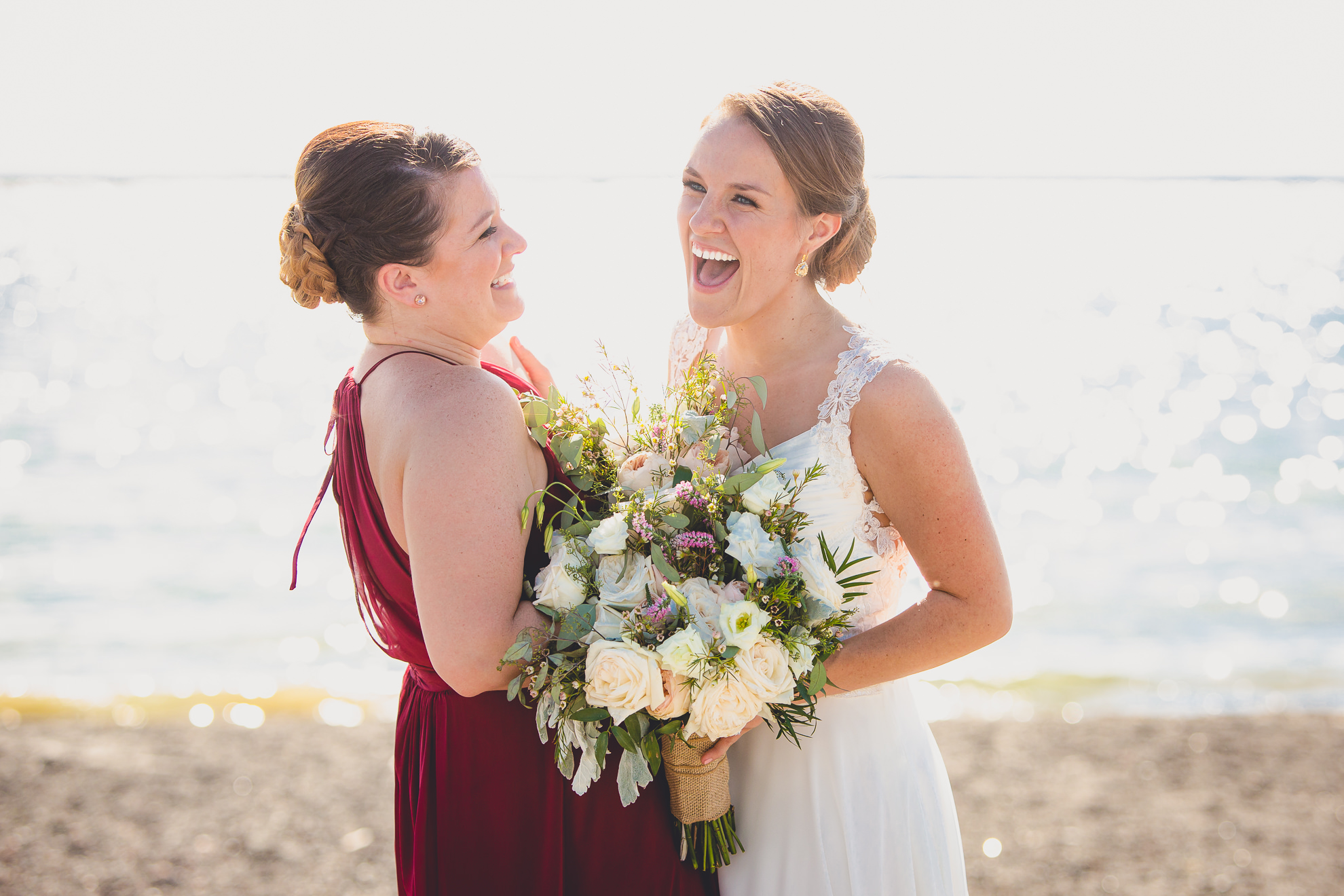 bride and maid of honor laugh at wedding at Gallagher Beach on Outer Harbor of Buffalo, NY