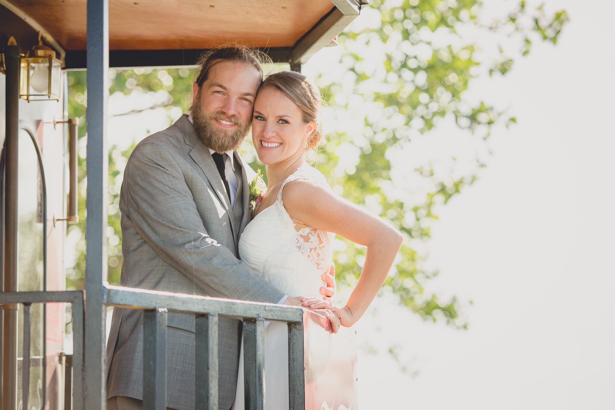 bride and groom smile for photographer on back of trolley at wedding at Outer Harbor in Buffalo, NY