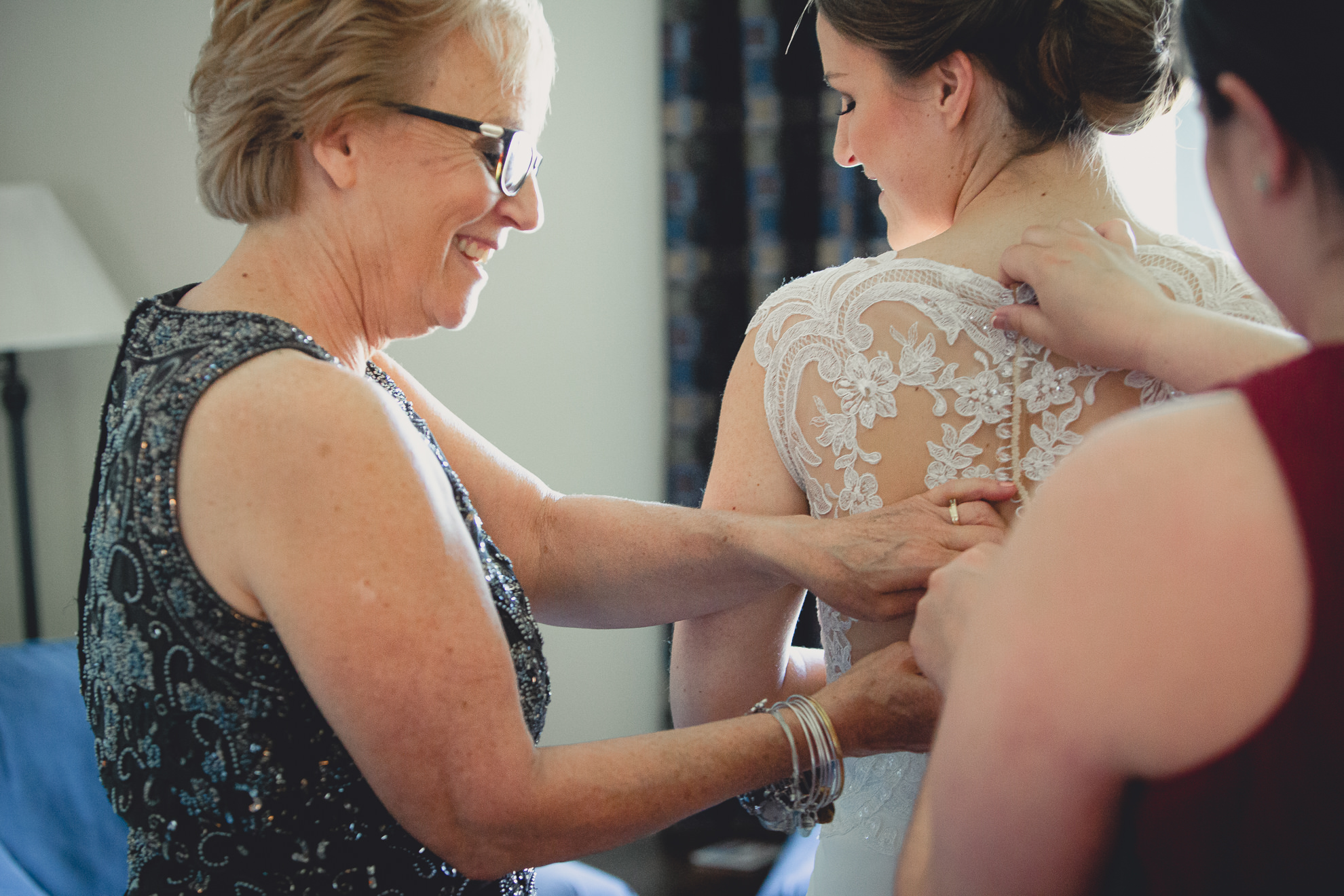 mother buttons bride dress before wedding ceremony in Buffalo, NY