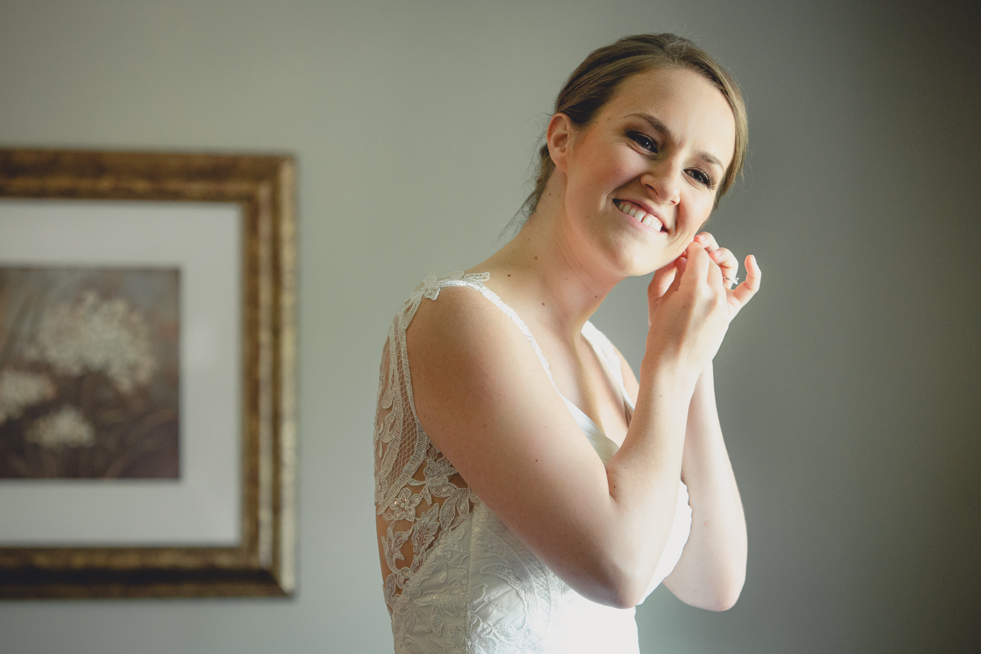 bride puts on earrings before wedding ceremony in Buffalo, NY
