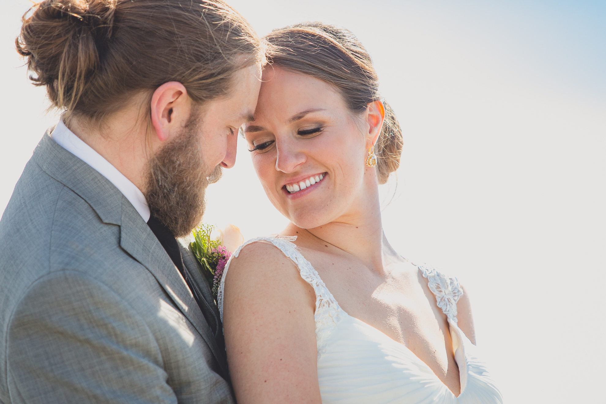 bride and groom pose for photographer at wedding on pier at Gallagher Beach on Outer Harbor of Buffalo, NY