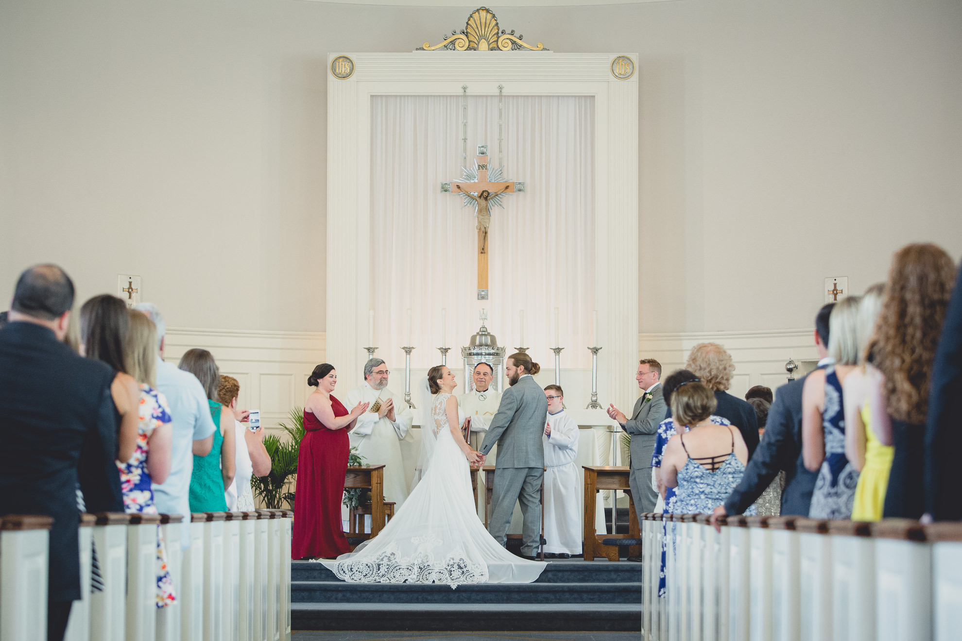 bride and groom smile at each other during wedding ceremony at St. John the Baptist church in Kenmore, NY