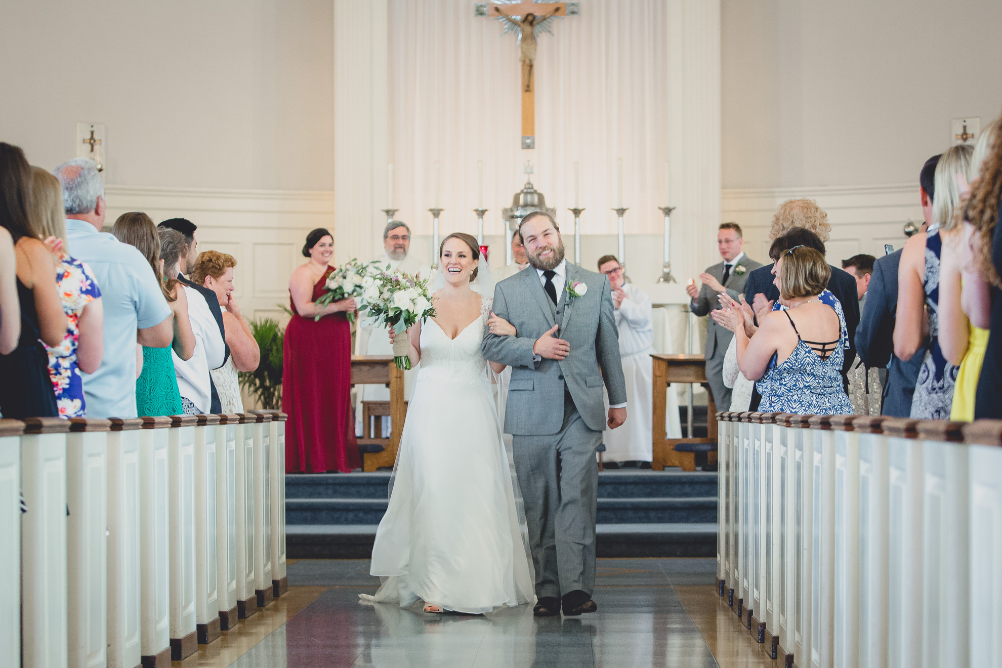 bride and groom exit church after wedding ceremony at St. John the Baptist church in Kenmore, NY