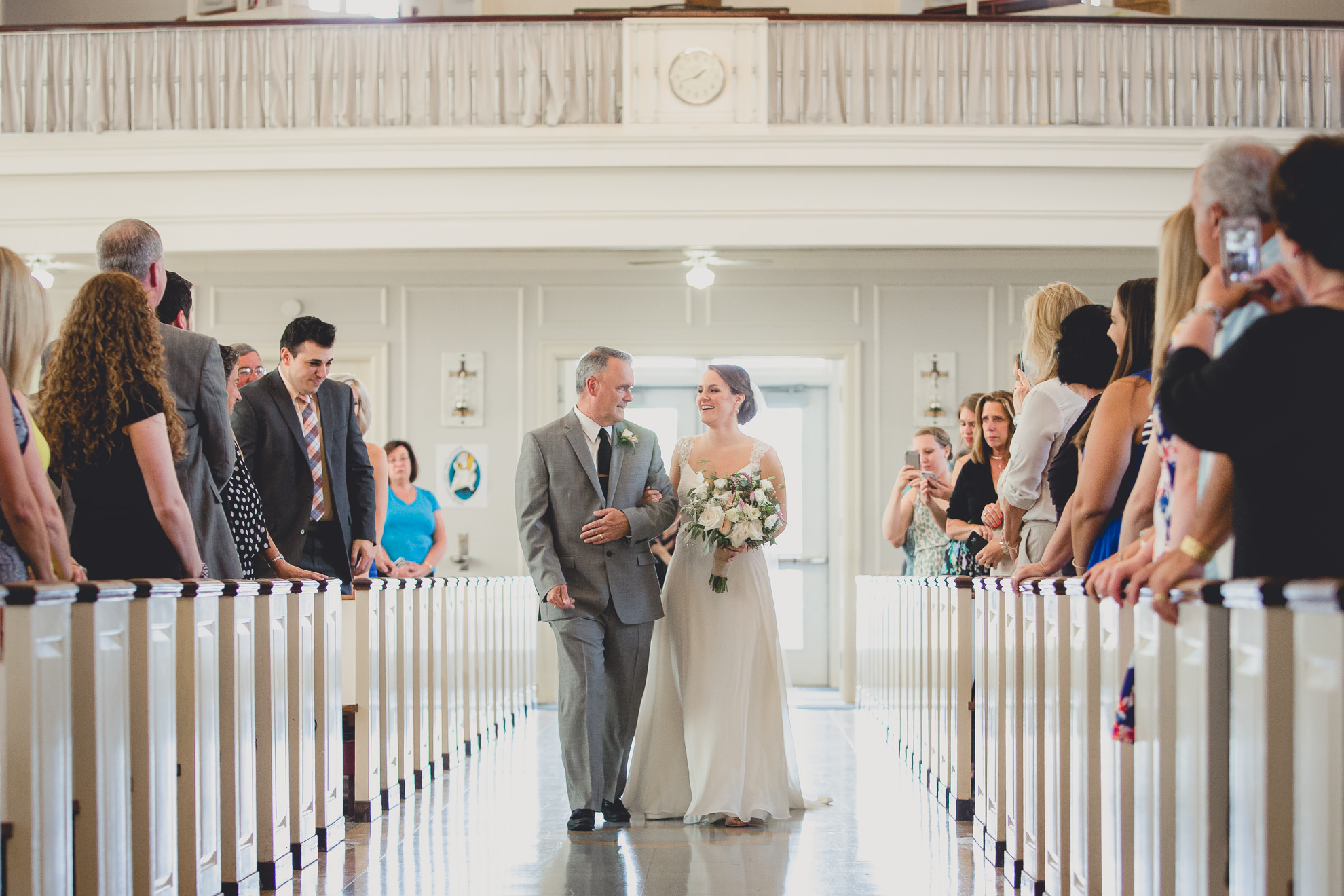 father and bride walk down aisle during wedding ceremony at St. John the Baptist church in Kenmore, NY