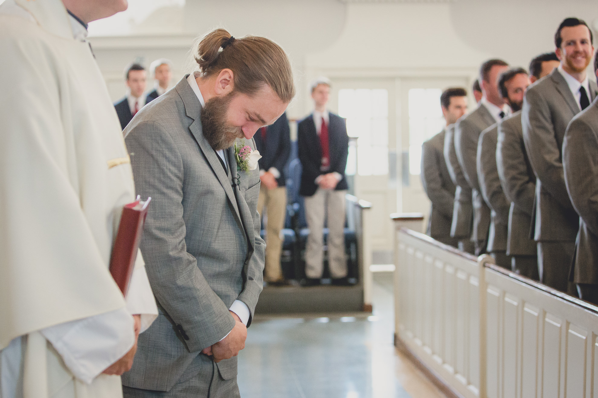 groom cries as bride walks down aisle during wedding ceremony at St. John the Baptist church in Kenmore, NY