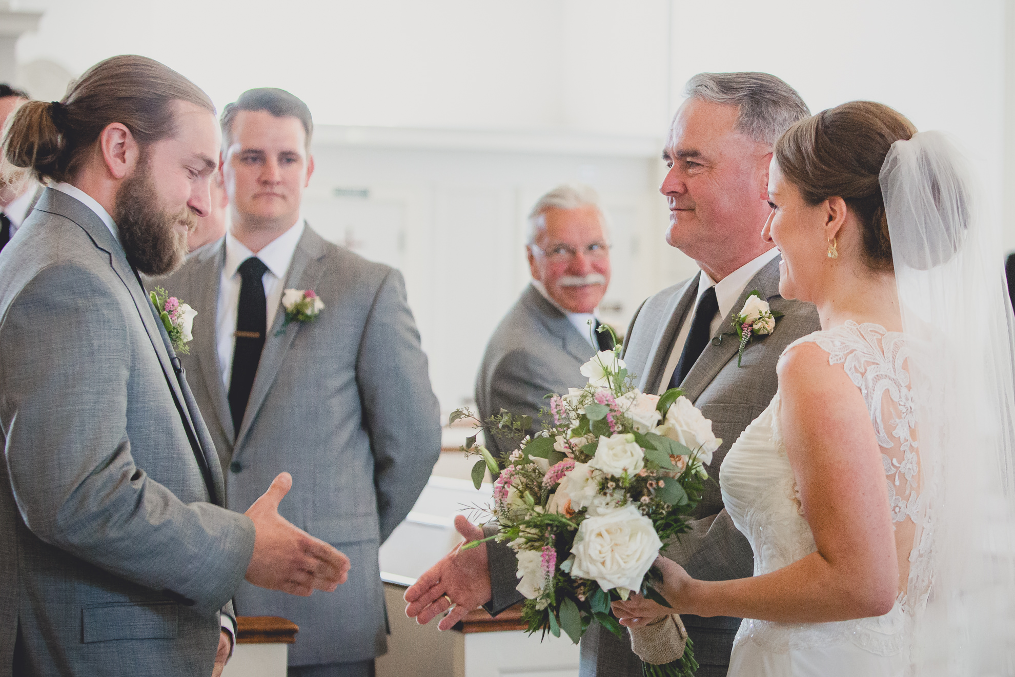 groom shakes father of brides hand during wedding ceremony at St. John the Baptist church in Kenmore, NY