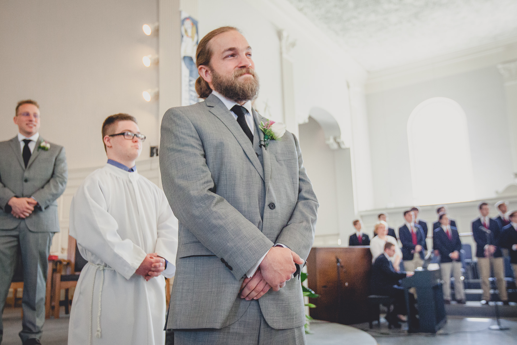 groom cries as bride walks down aisle during wedding ceremony at St. John the Baptist church in Kenmore, NY