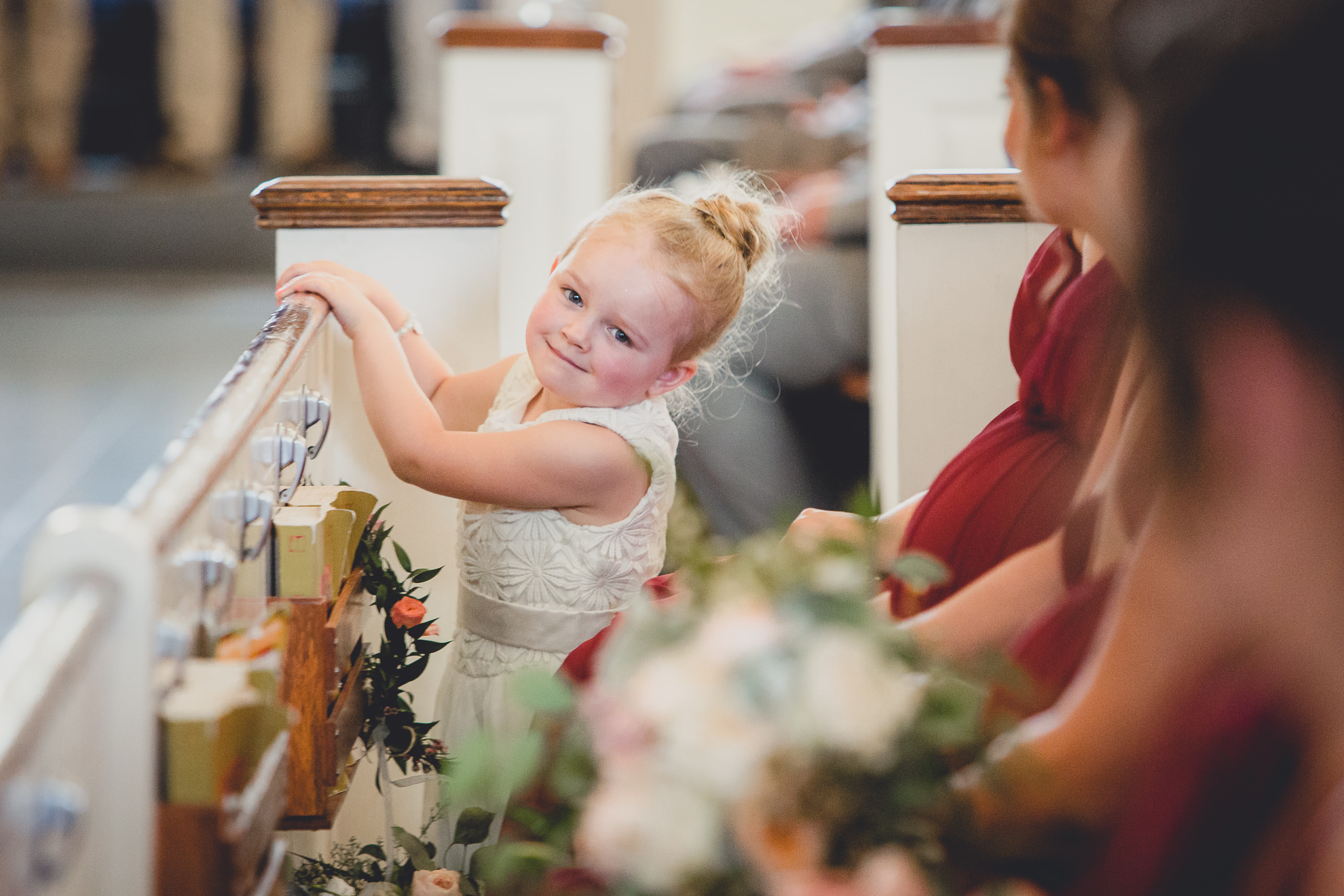 flower girls smiles for photographer during wedding ceremony at St. John the Baptist church in Kenmore, NY