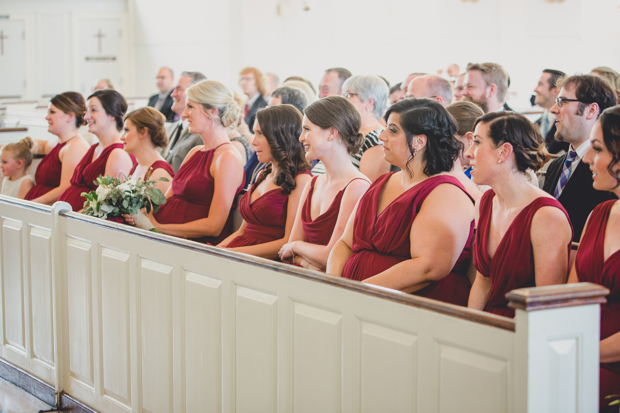 bridesmaids watch during wedding ceremony at St. John the Baptist church in Kenmore, NY