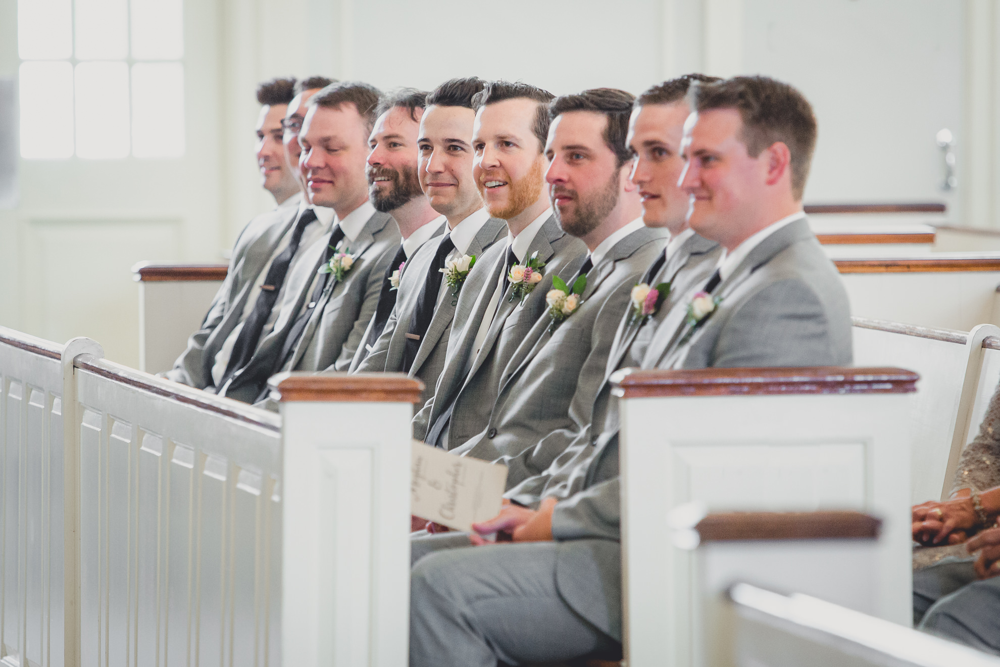 groomsmen watch during wedding ceremony at St. John the Baptist church in Kenmore, NY