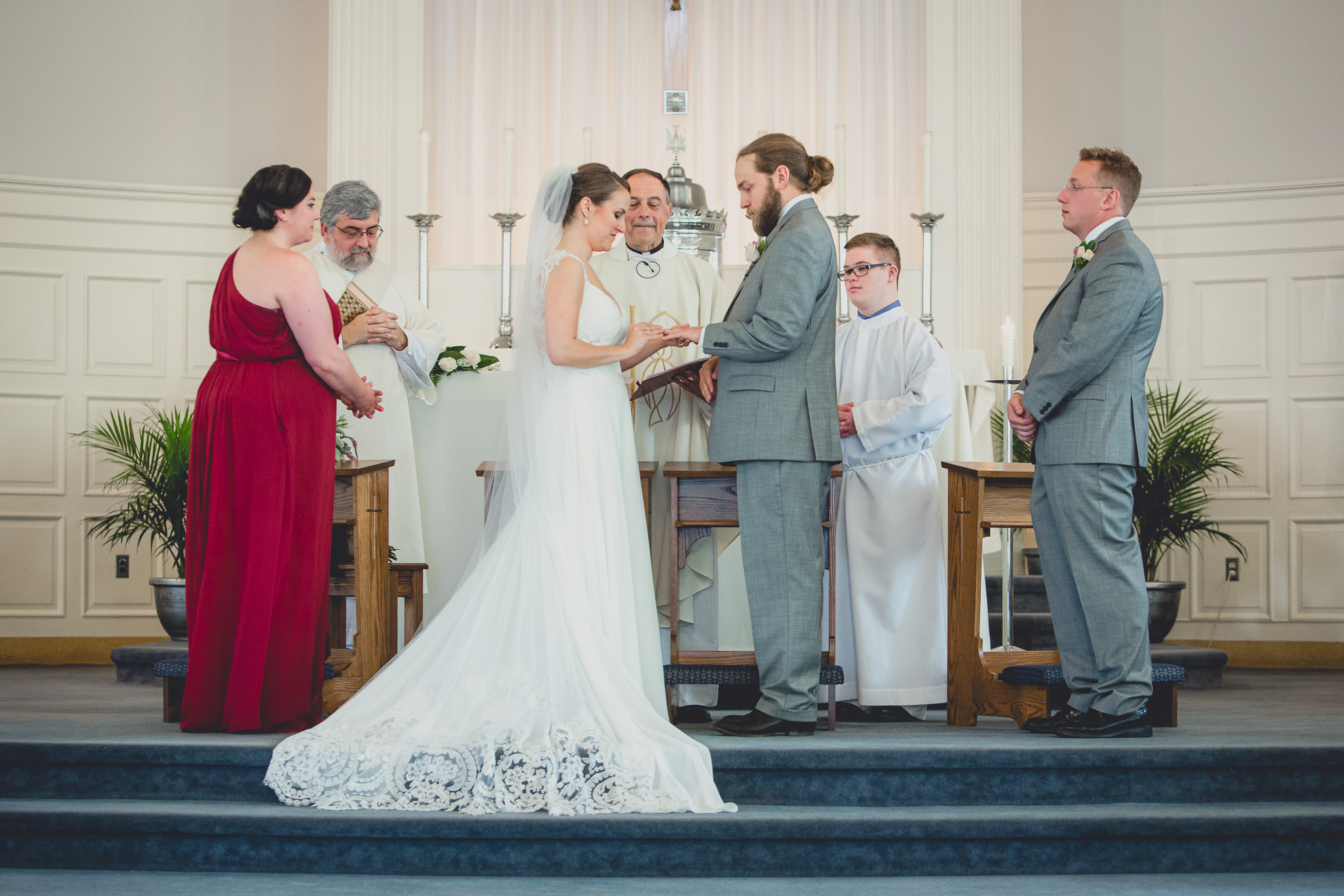 bride and groom exchange rings during wedding ceremony at St. John the Baptist church in Kenmore, NY