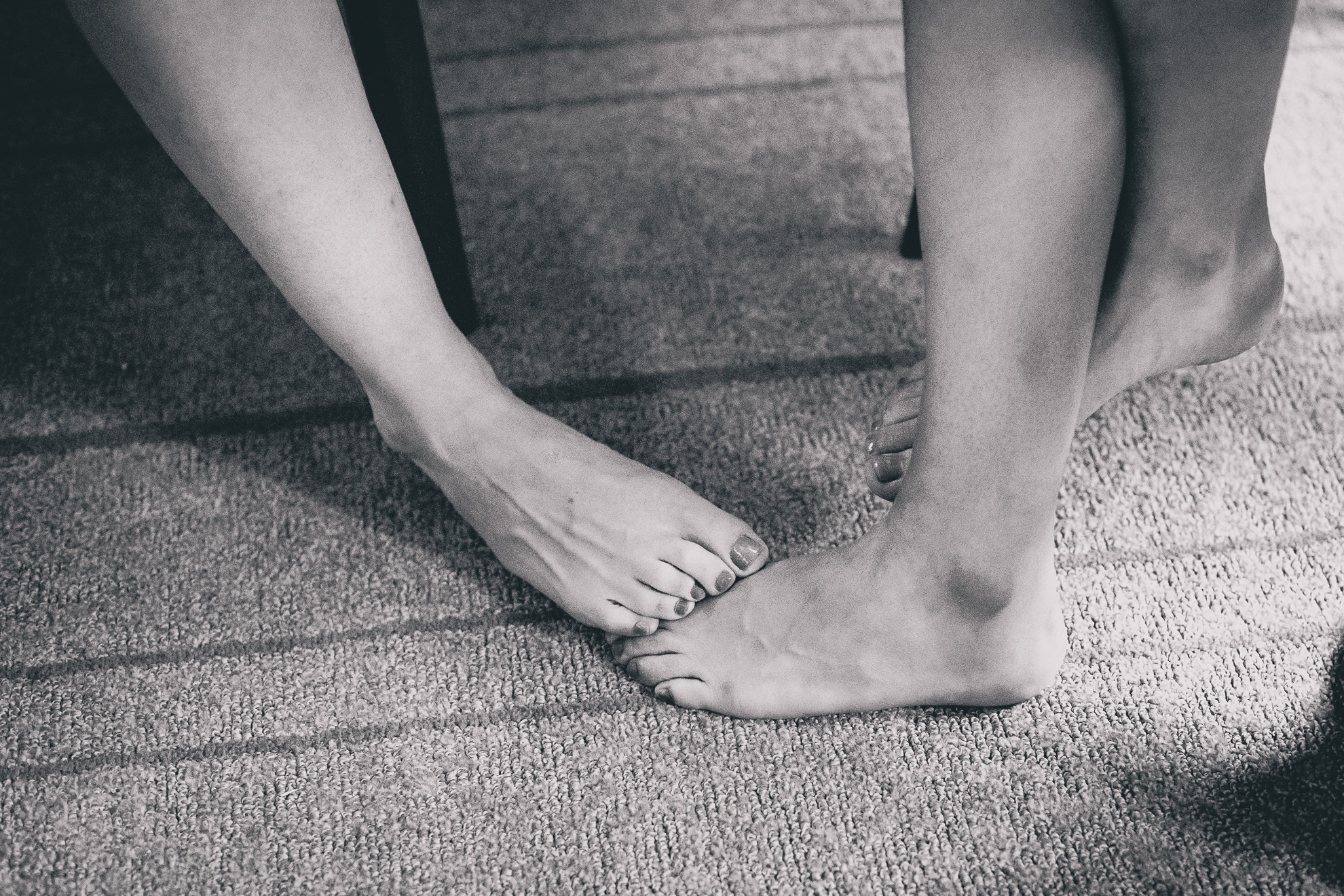 brides touch feet while getting ready for wedding at Hotel Henry in Buffalo, NY