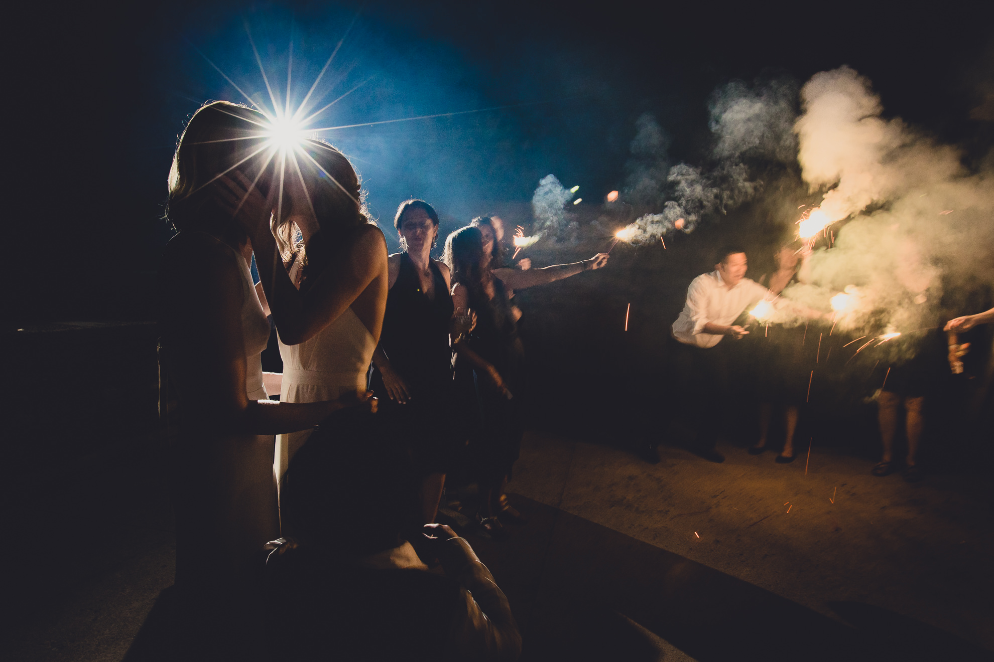brides kiss during sprakler exit at wedding at Marcy Casino in Delaware Park in Buffalo, NY