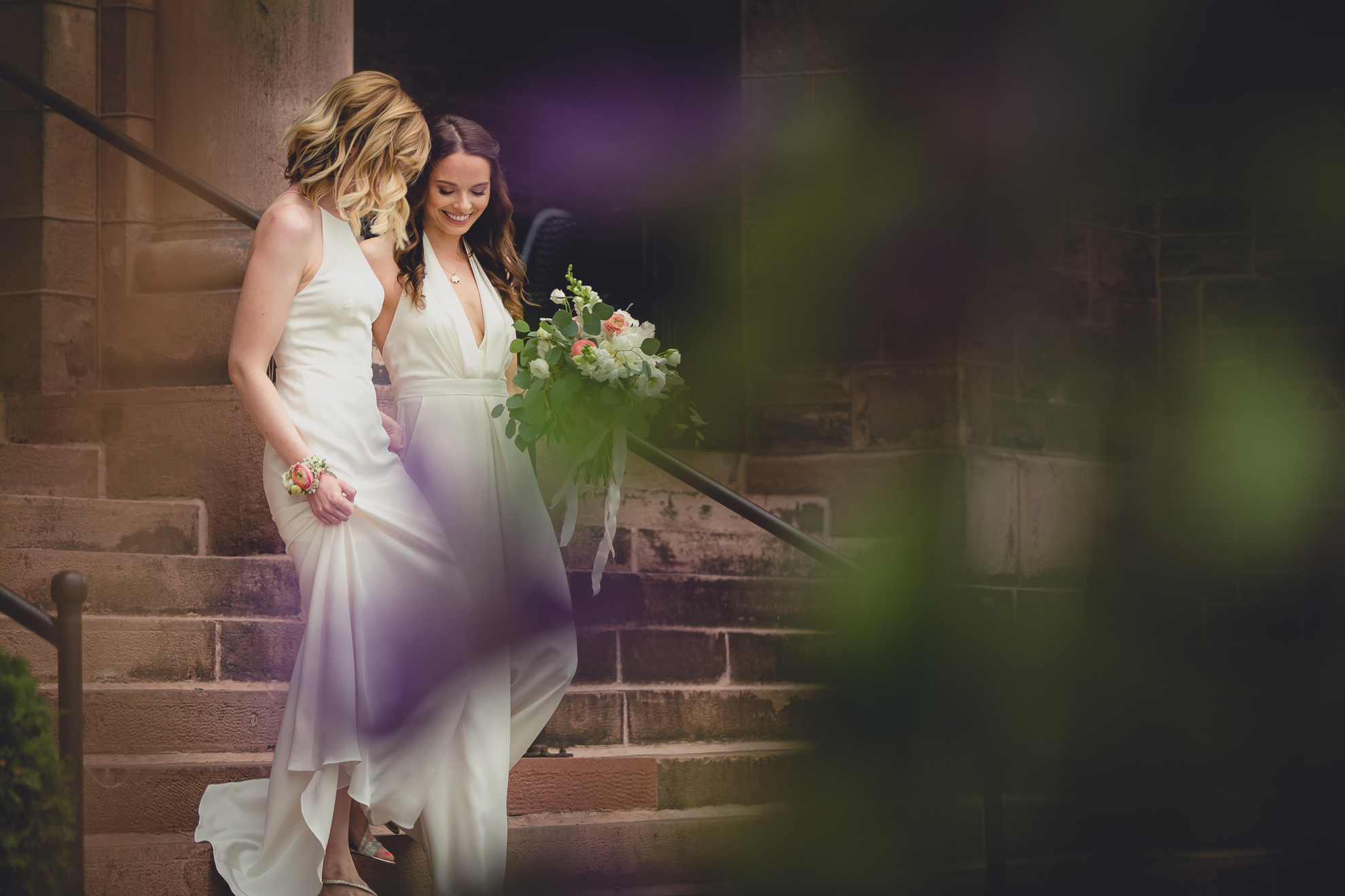 brides walk down steps during portrait session before wedding at Hotel Henry in Buffalo, NY
