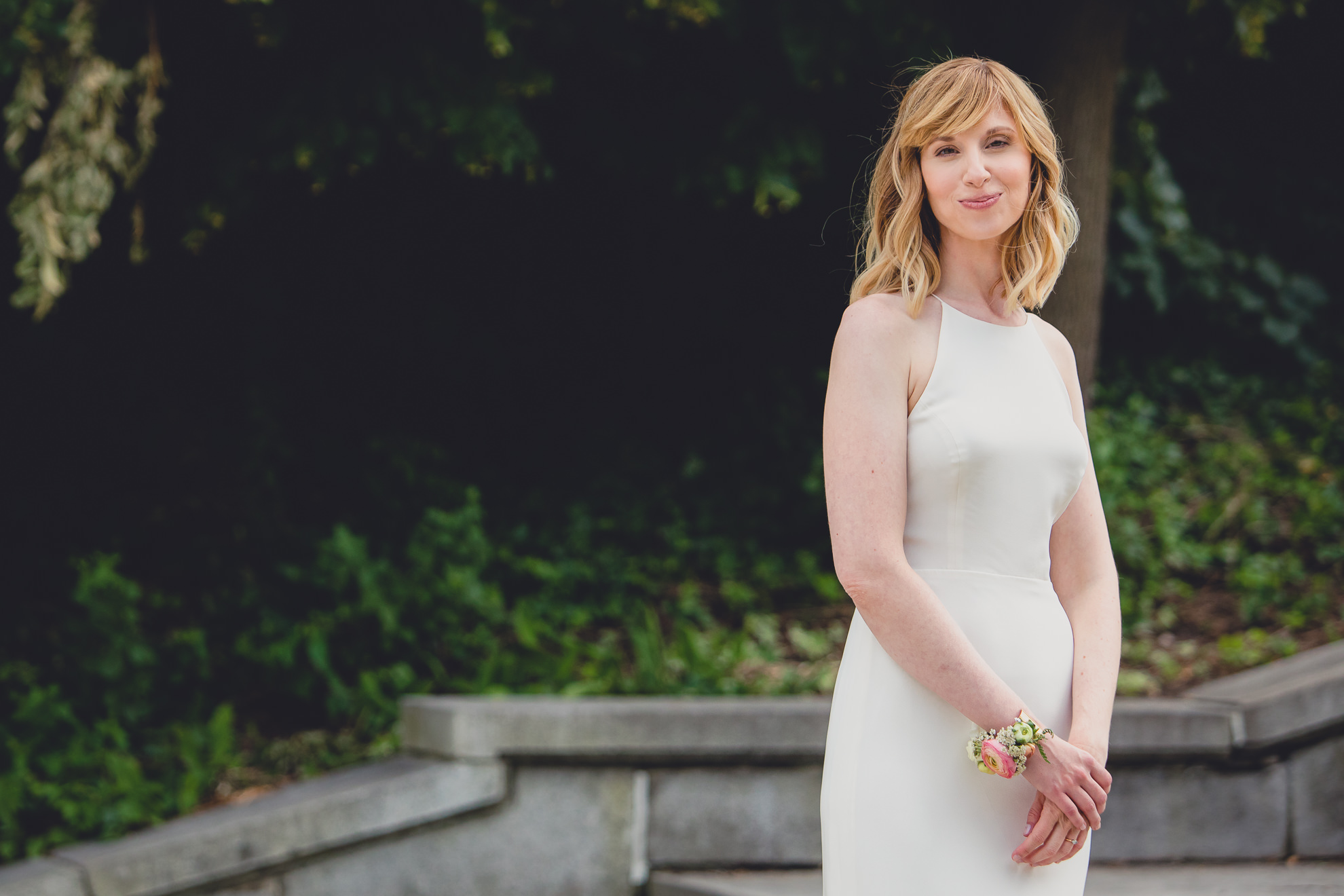 bride smiles for photographer for portrait on wedding day ceremony in front of Albright Knox in Delaware Park in Buffalo, NY