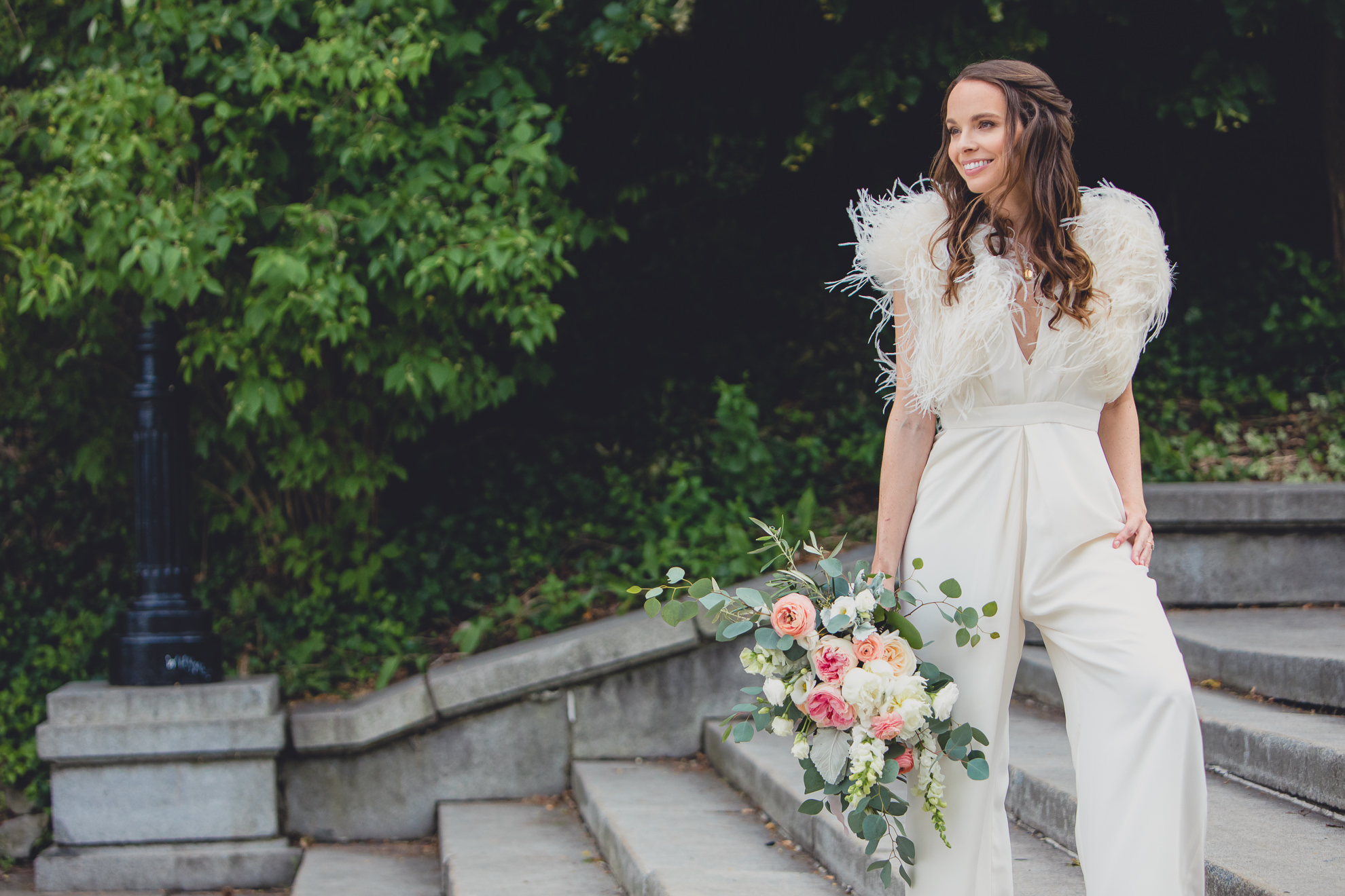 bride poses for portrait on wedding day ceremony in front of Albright Knox in Delaware Park in Buffalo, NY