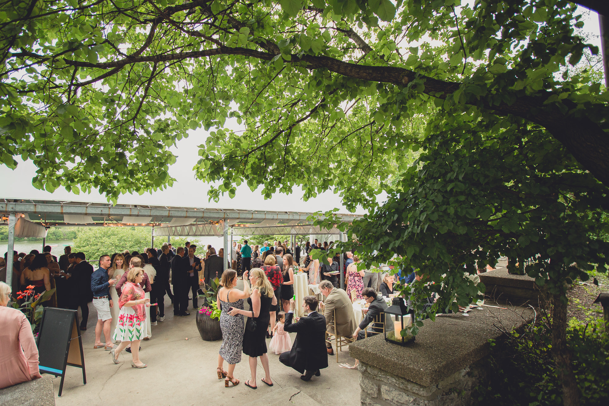 guests mingle during cocktail hour on the terrace during wedding at Marcy Casino in Delaware Park in Buffalo, NY