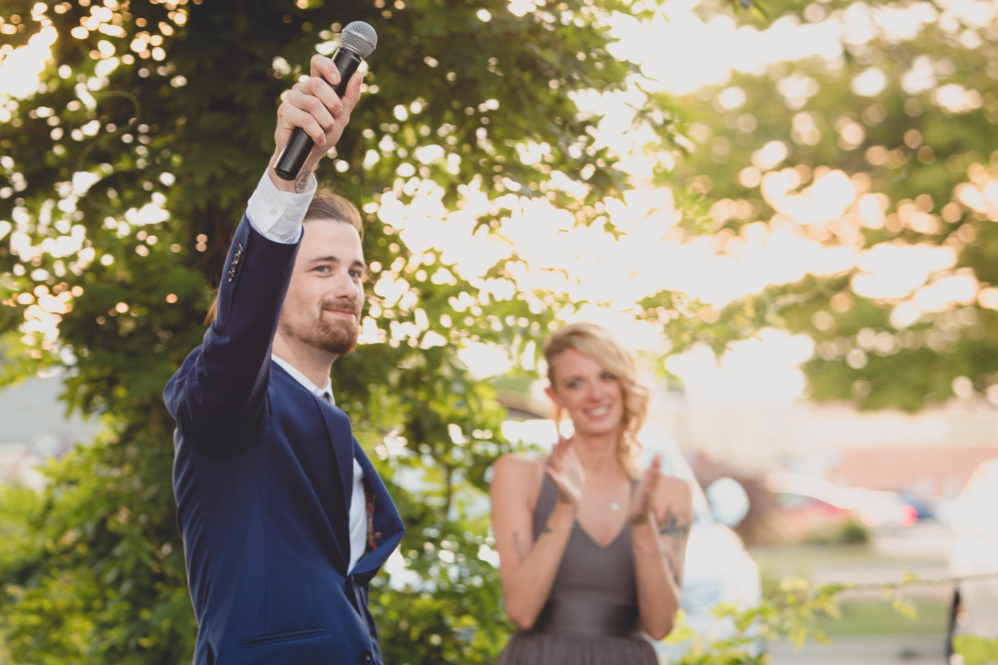 best man and maid of honor deliver speeches during outdoor wedding reception at the Revelry in Rochester, NY 