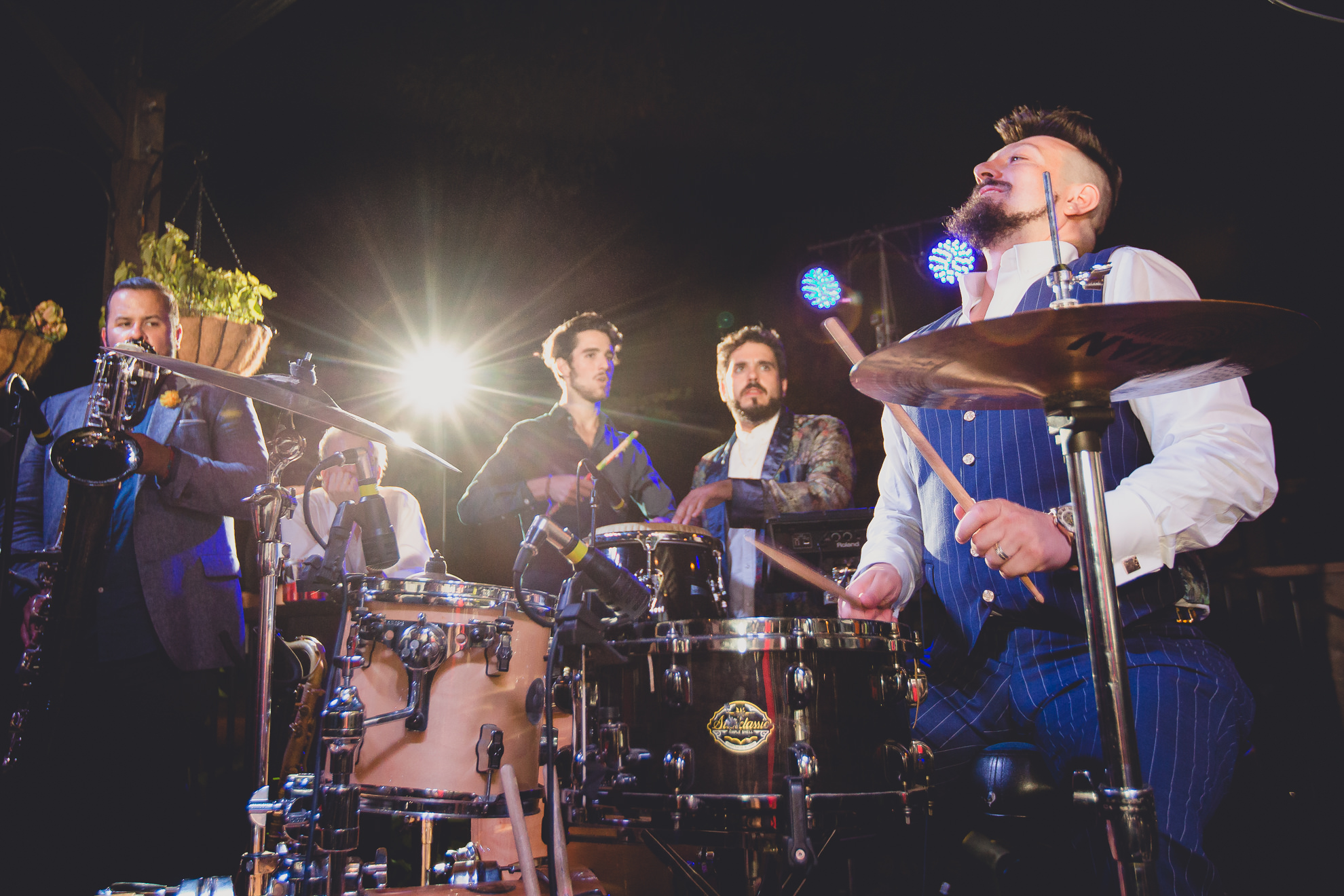 groom performs on drums with band emefe during outdoor wedding reception at the Revelry in Rochester, NY 