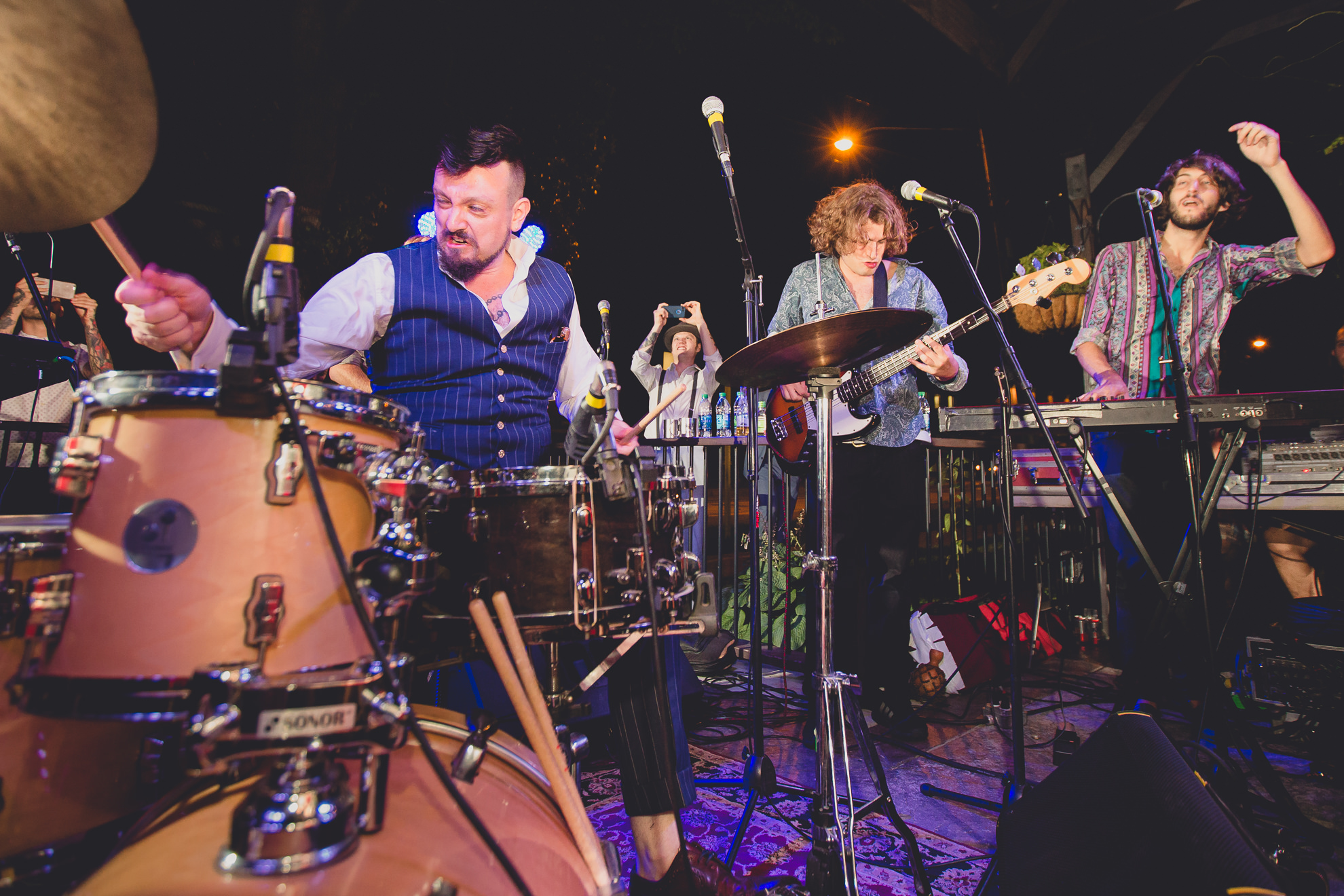 groom plays drums with band emefe during outdoor wedding reception at the Revelry in Rochester, NY 