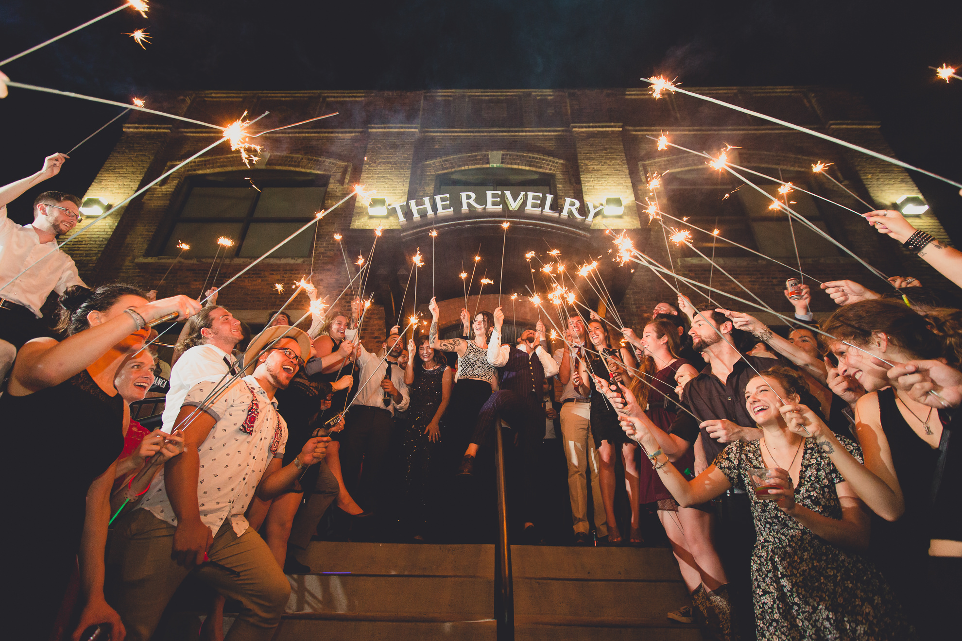 bride and grooms formal exit beneath sparklers during outdoor wedding reception at the Revelry in Rochester, NY 