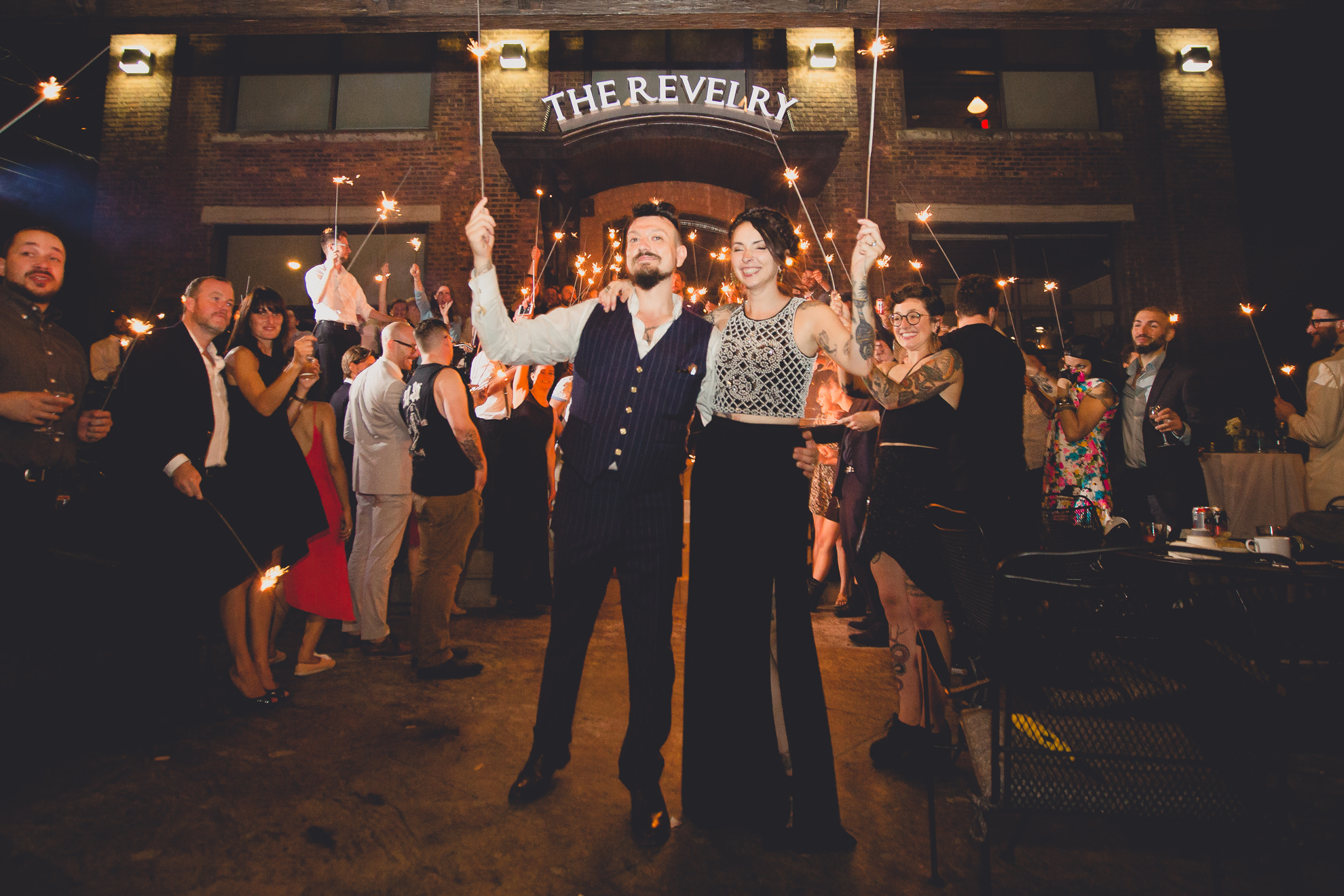 bride and grooms formal exit beneath sparklers during outdoor wedding reception at the Revelry in Rochester, NY 