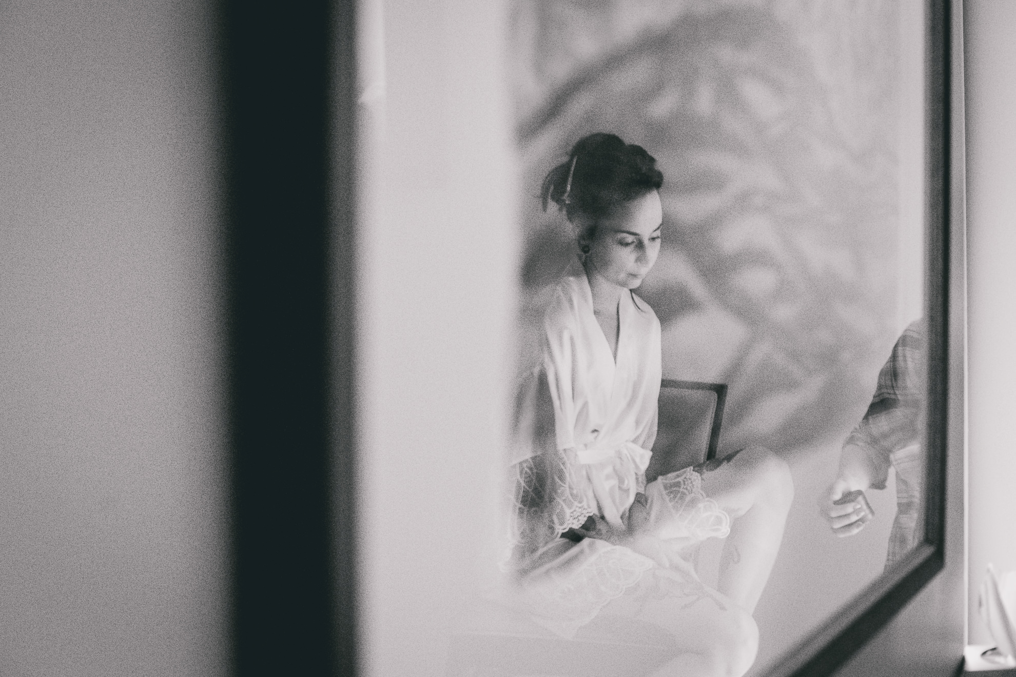 brides reflection seen in glass of artwork Strathallan Hotel in Rochester, NY before wedding