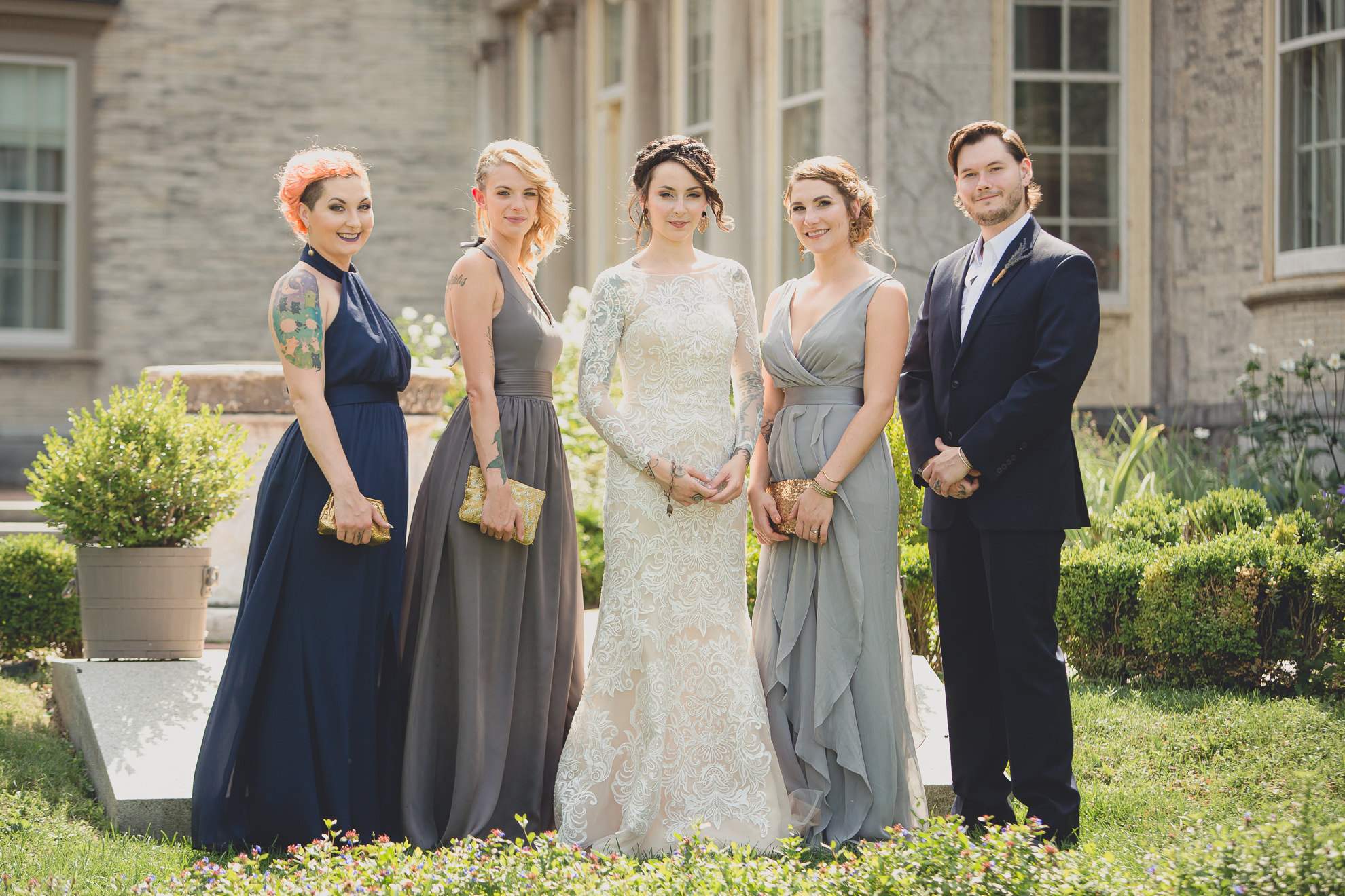 wedding party poses for photographer before garden wedding ceremony at the George Eastman House in Rochester, NY 