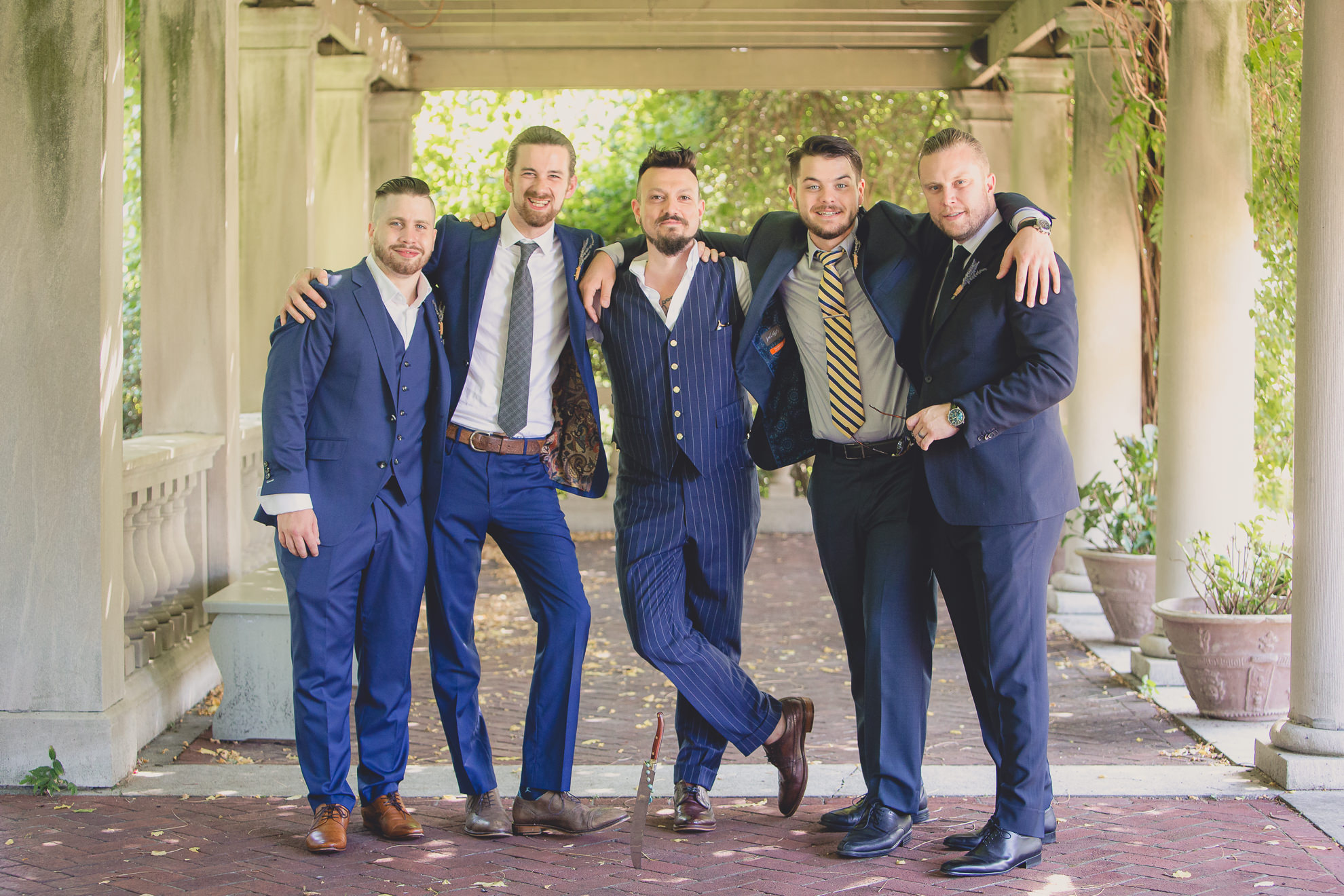 wedding party poses for photographer before garden wedding ceremony at the George Eastman House in Rochester, NY 