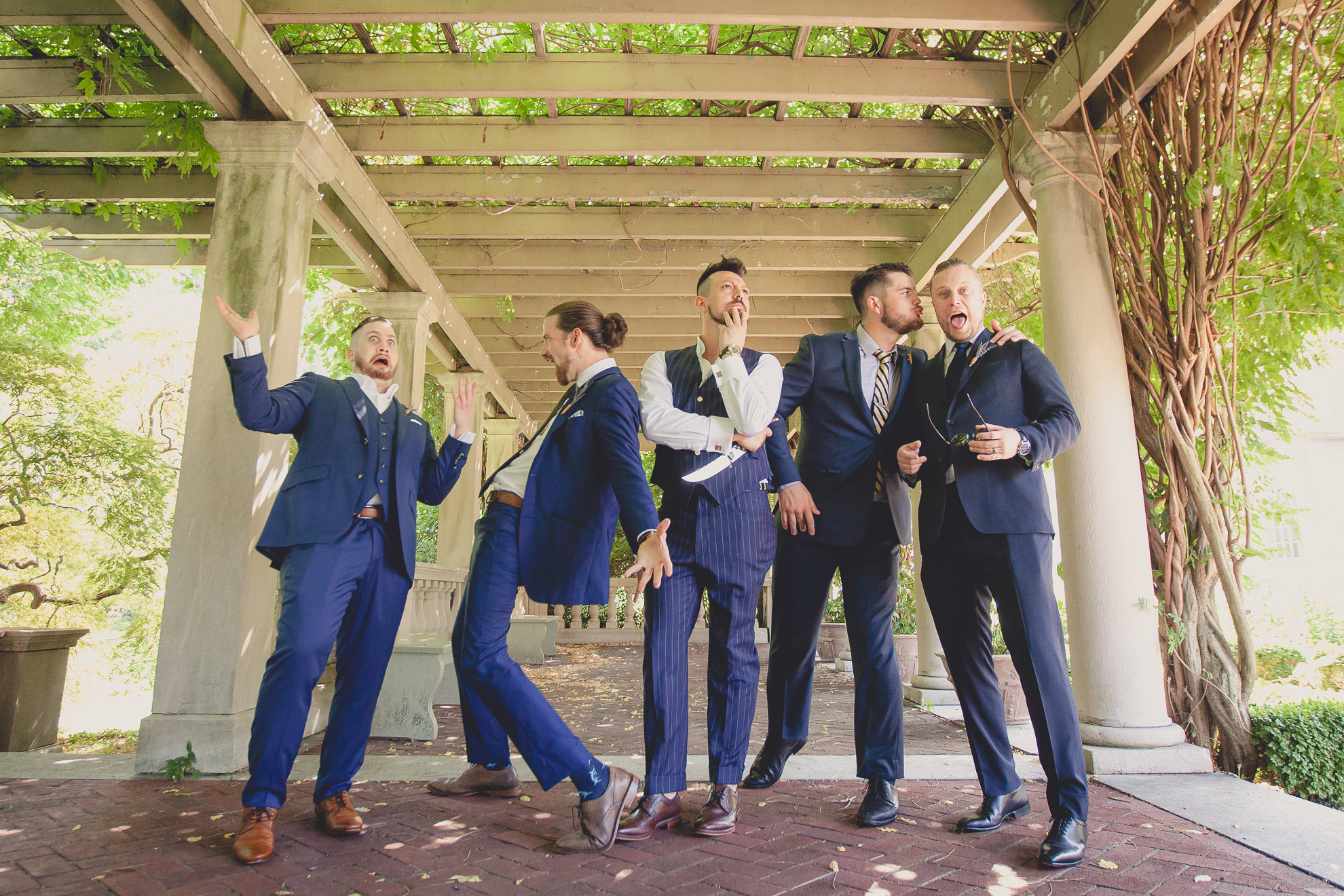 wedding party poses for photographer before garden wedding ceremony at the George Eastman House in Rochester, NY 