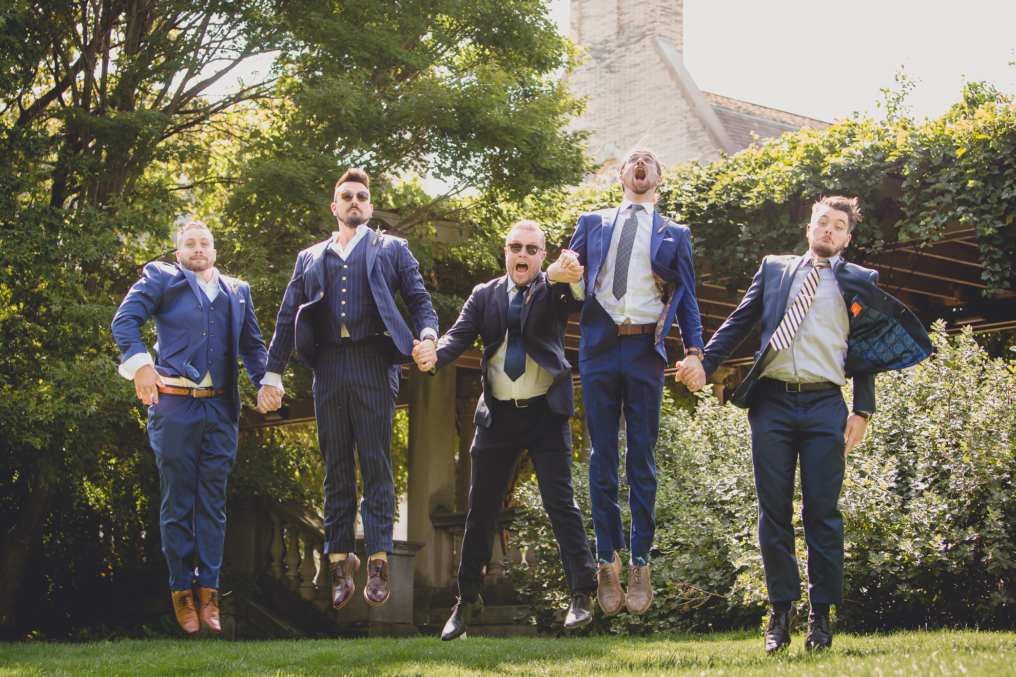 wedding party poses for photographer before garden wedding ceremony at the George Eastman House in Rochester, NY 