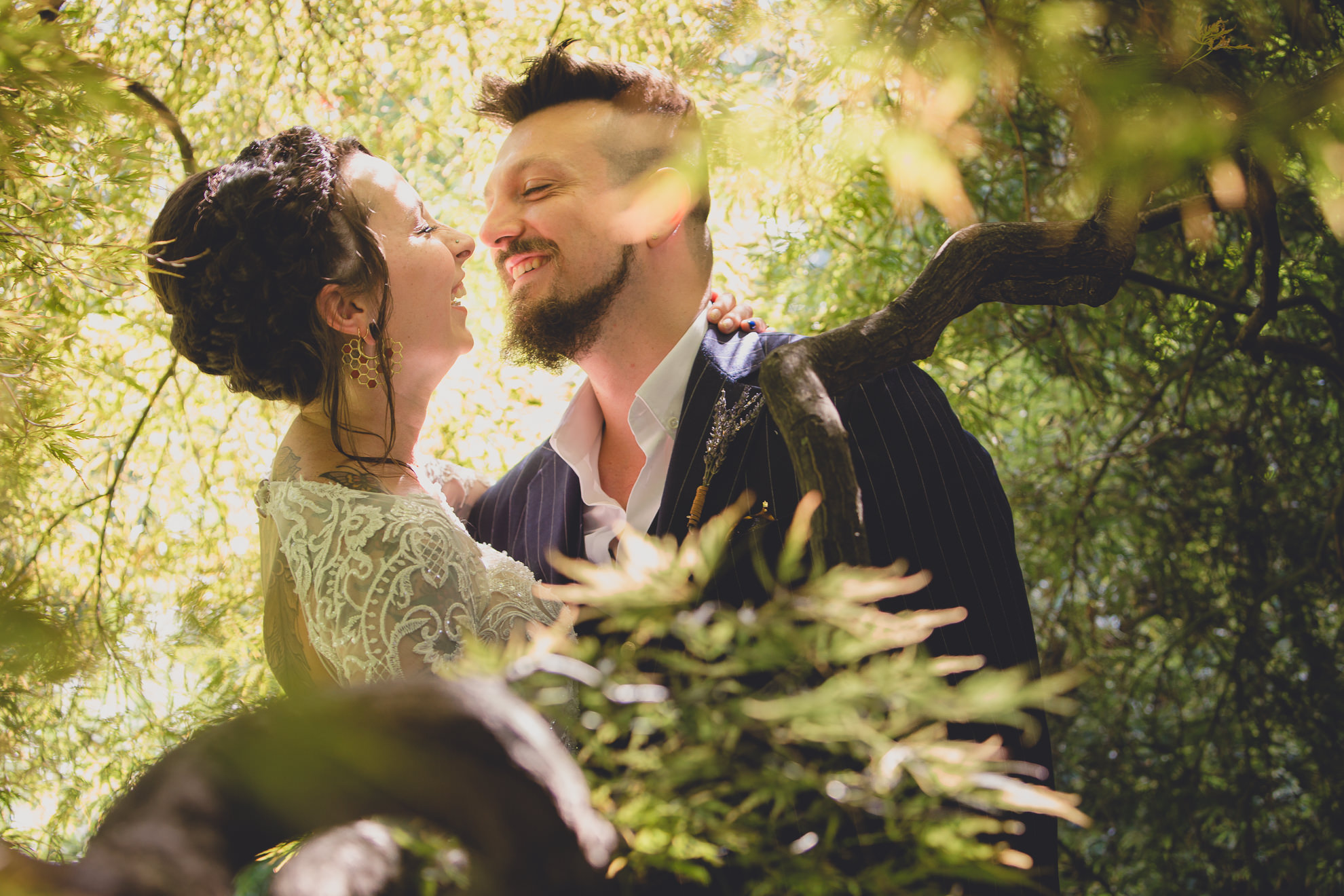 bride and groom pose for photographer before garden wedding ceremony at the George Eastman House in Rochester, NY 