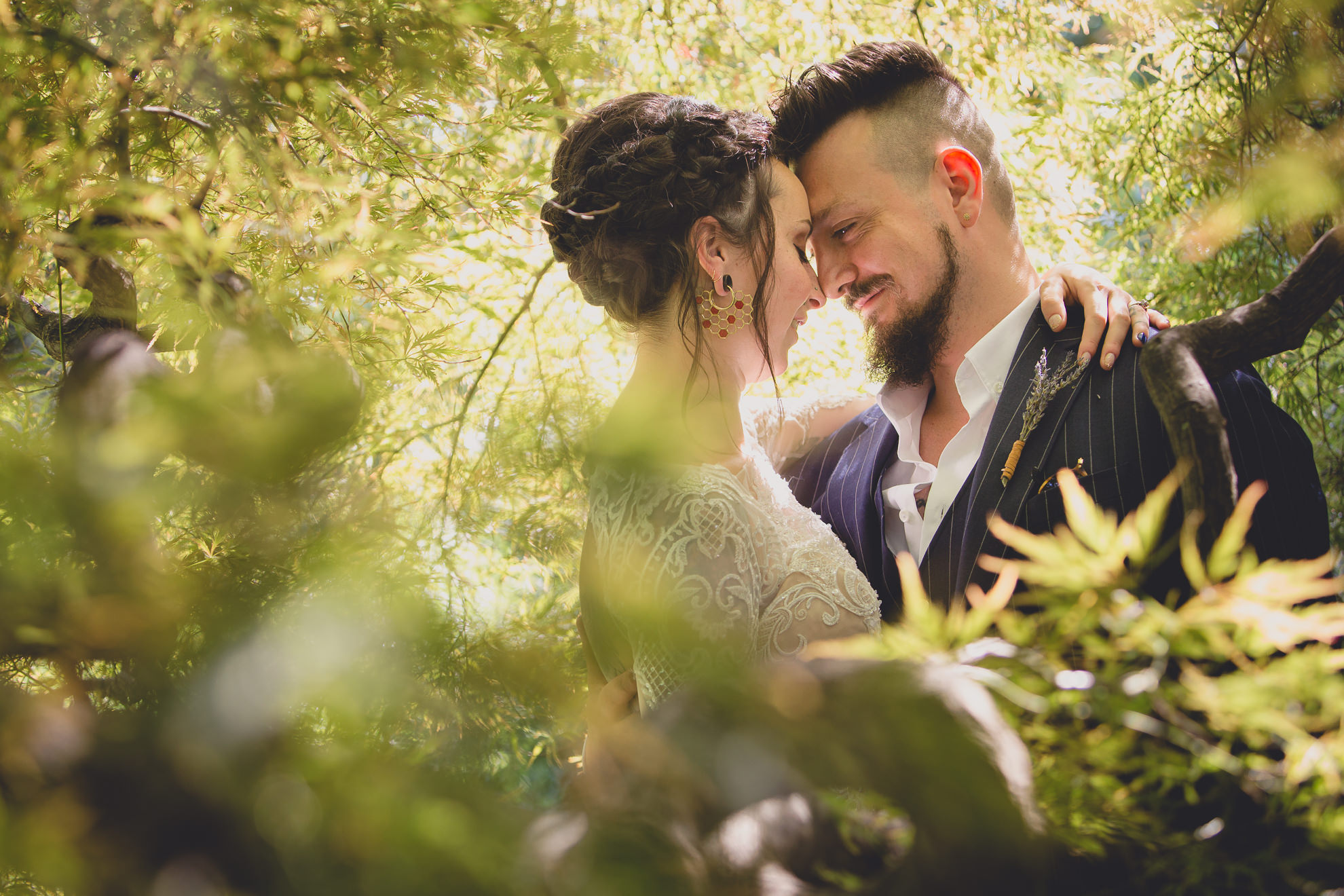 bride and groom pose for photographer before garden wedding ceremony at the George Eastman House in Rochester, NY 