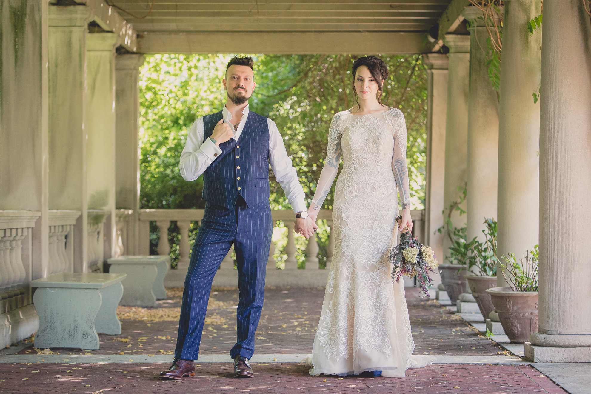 bride and groom pose for photographer before garden wedding ceremony at the George Eastman House in Rochester, NY 