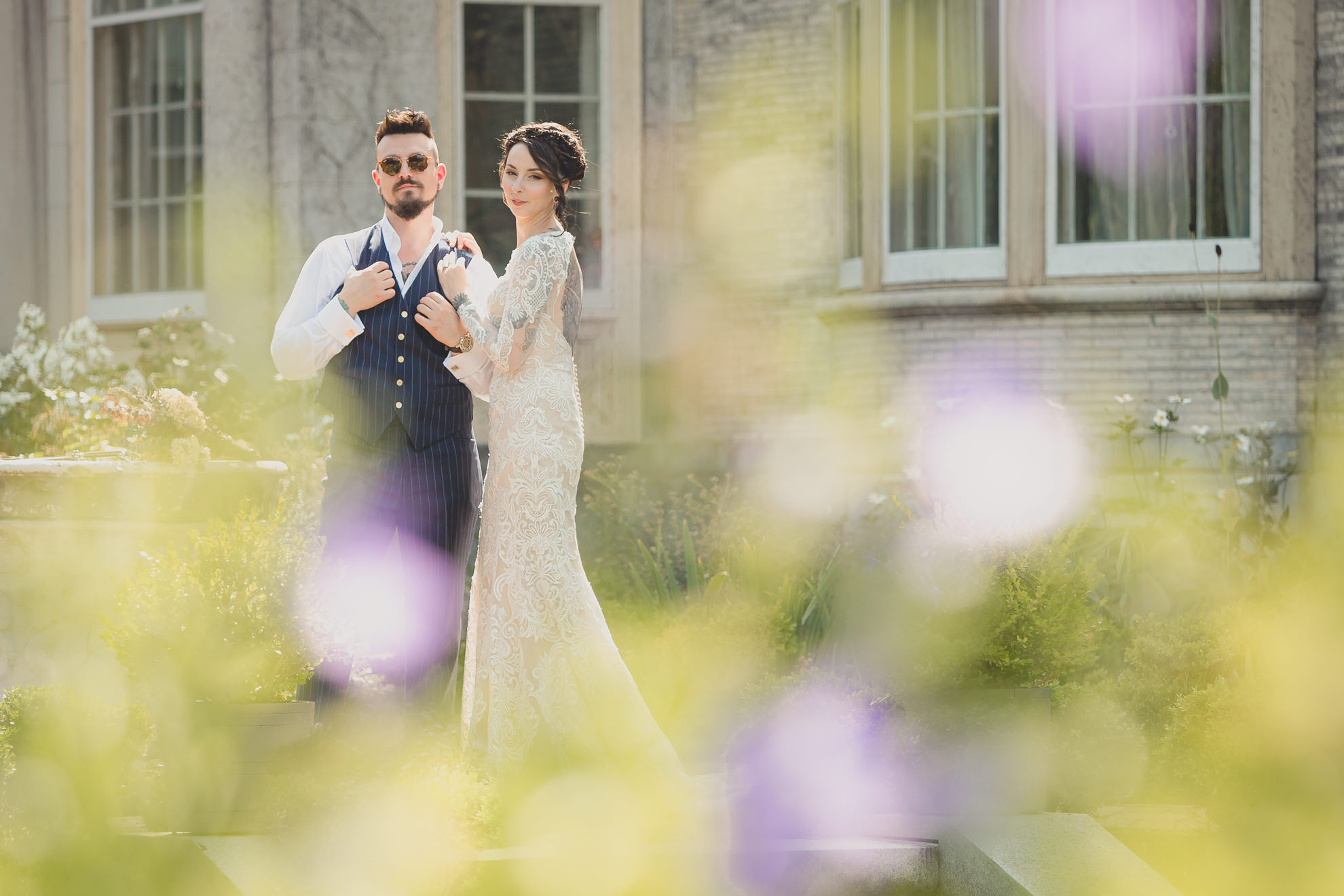 bride and groom pose for photographer before garden wedding ceremony at the George Eastman House in Rochester, NY 