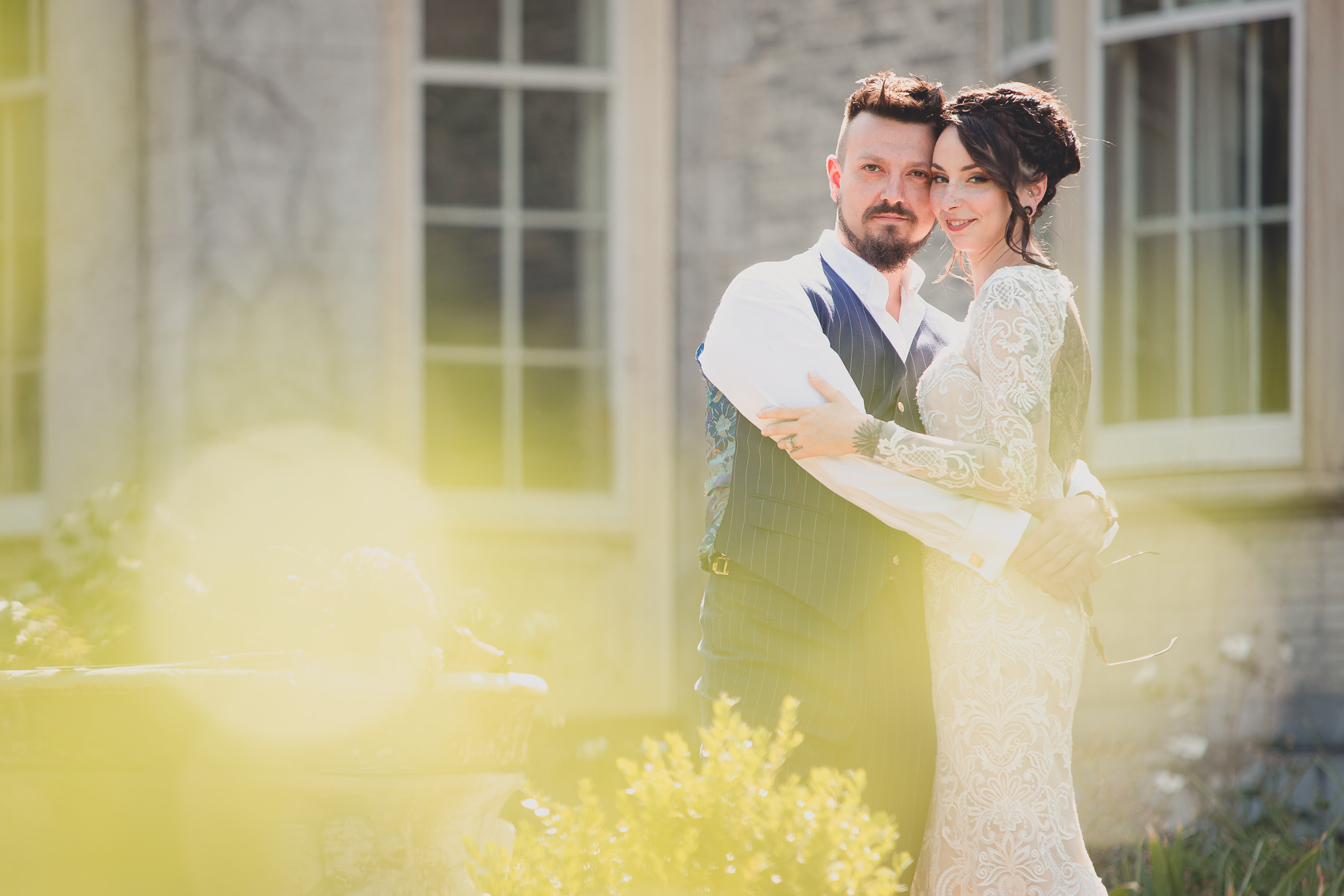 bride and groom pose for photographer before garden wedding ceremony at the George Eastman House in Rochester, NY 