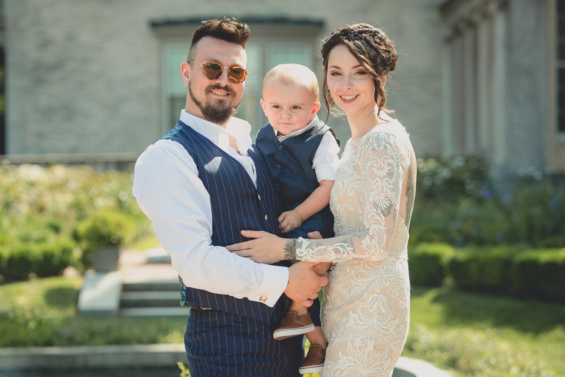 bride groom and son pose for photographer before garden wedding ceremony at the George Eastman House in Rochester, NY 