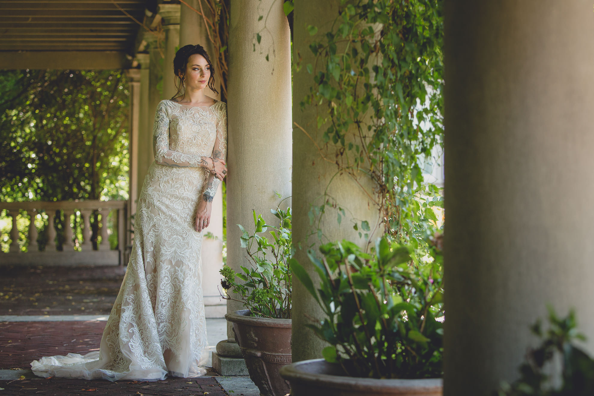 bride poses for photographer before garden wedding ceremony at the George Eastman House in Rochester, NY 