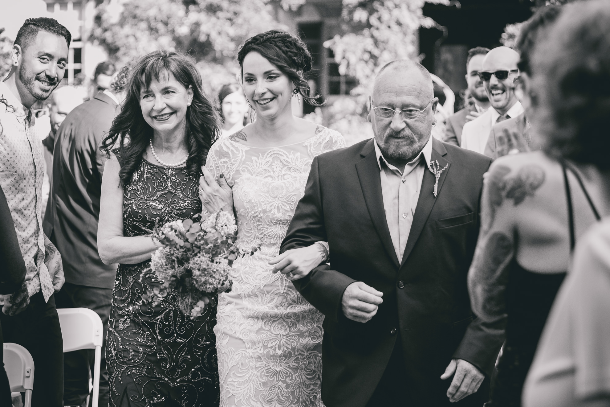bride and parents come down aisle during garden wedding ceremony at the George Eastman House in Rochester, NY 