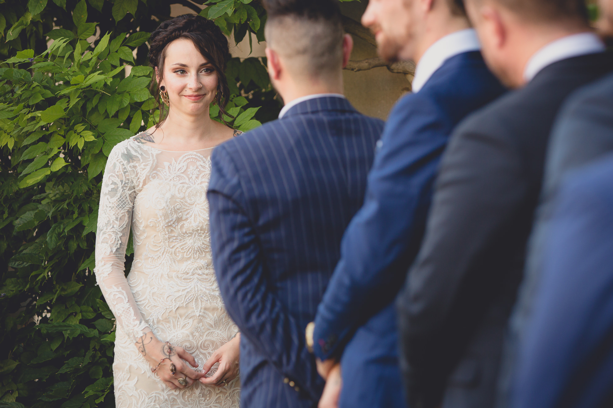 bride smiles at groom during garden wedding ceremony at the George Eastman House in Rochester, NY 