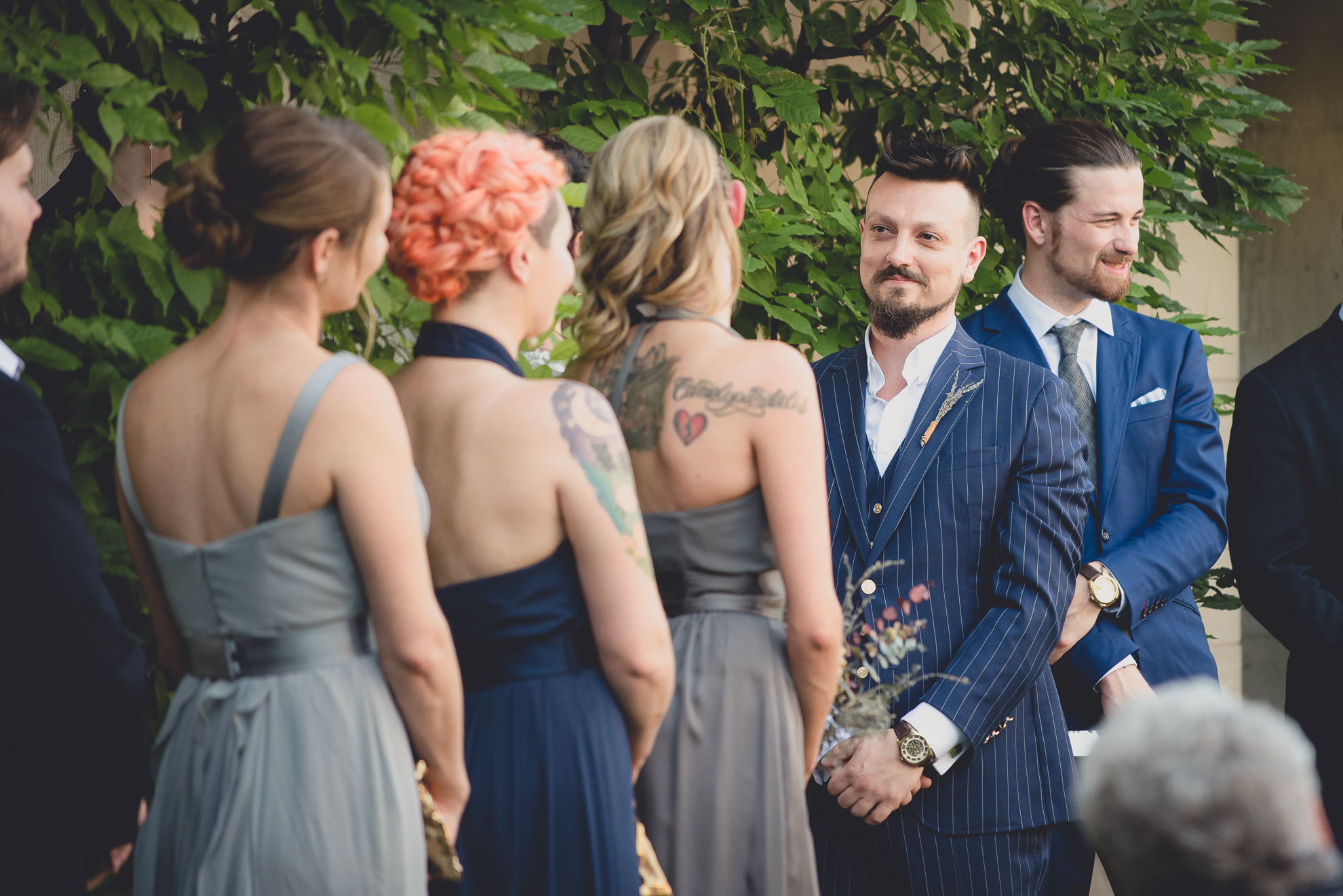 groom smiles at bride during garden wedding ceremony at the George Eastman House in Rochester, NY 