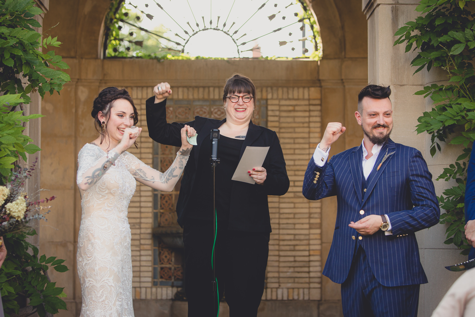 bride and groom fist pump during garden wedding ceremony at the George Eastman House in Rochester, NY 