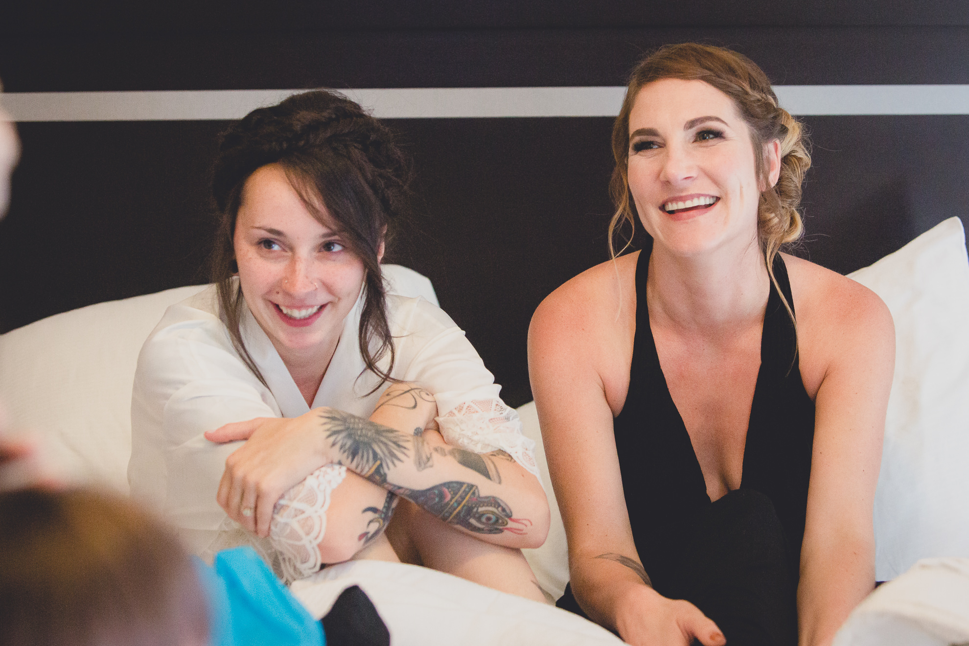 bride and bridesmaids laugh at Strathallan Hotel in Rochester, NY before wedding