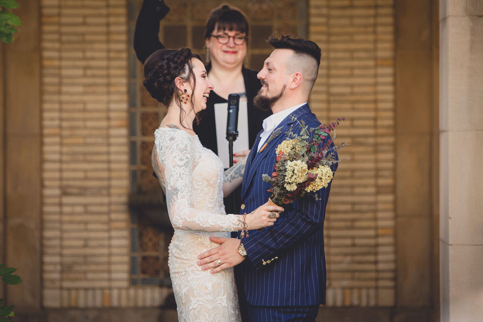 bride and groom smile at each other during garden wedding ceremony at the George Eastman House in Rochester, NY 