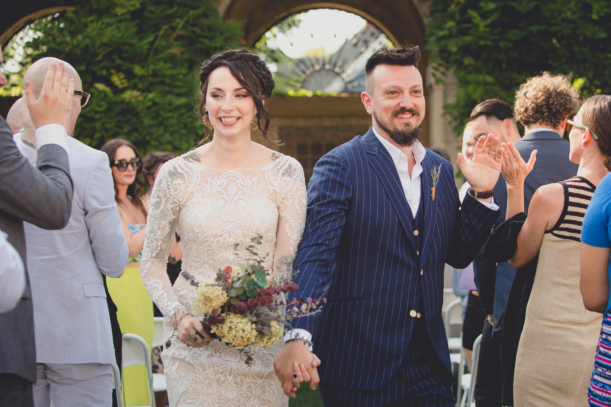 bride and groom walk up aisle during recessional during garden wedding ceremony at the George Eastman House in Rochester, NY 