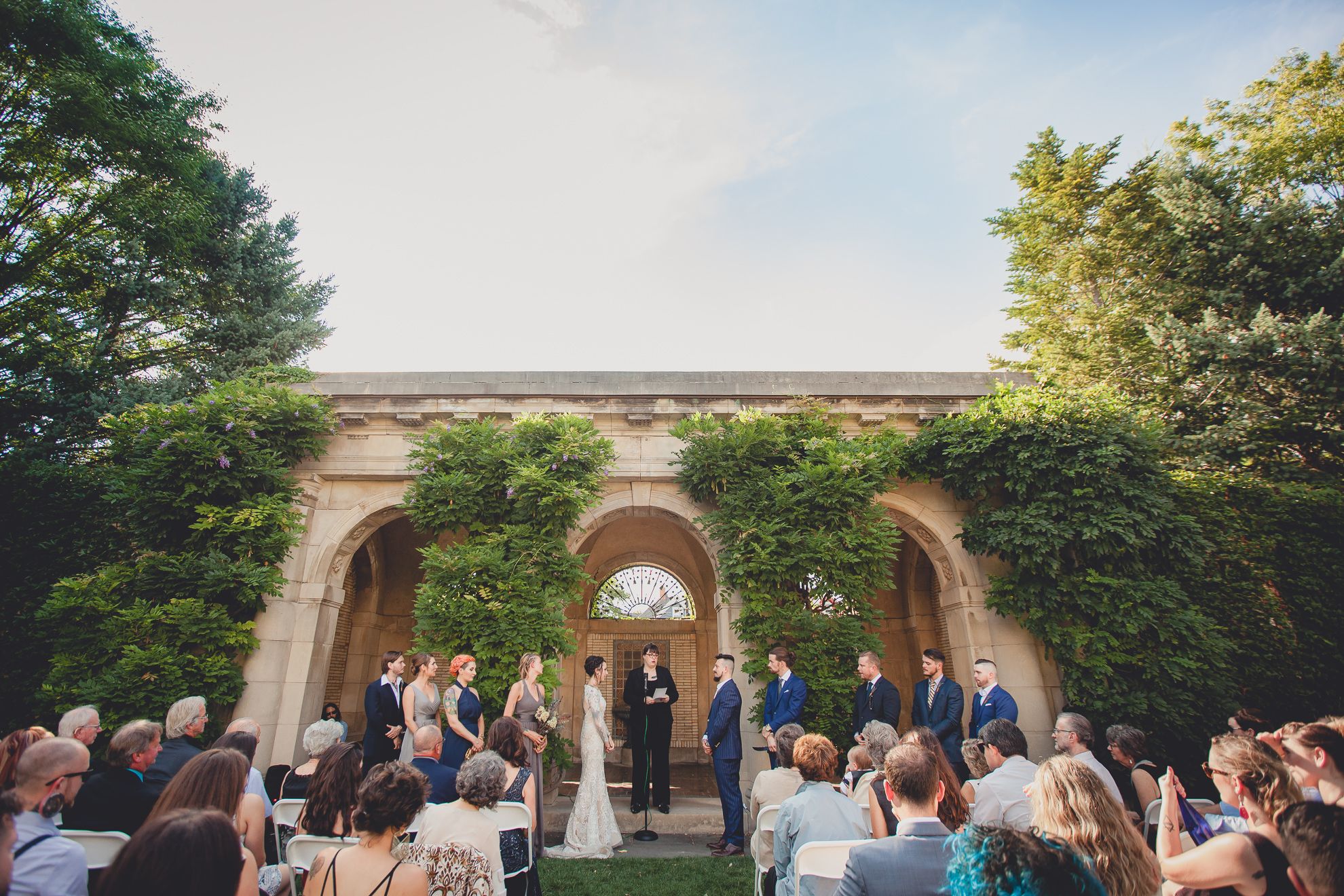 garden wedding ceremony in front of arches at the George Eastman House in Rochester, NY 